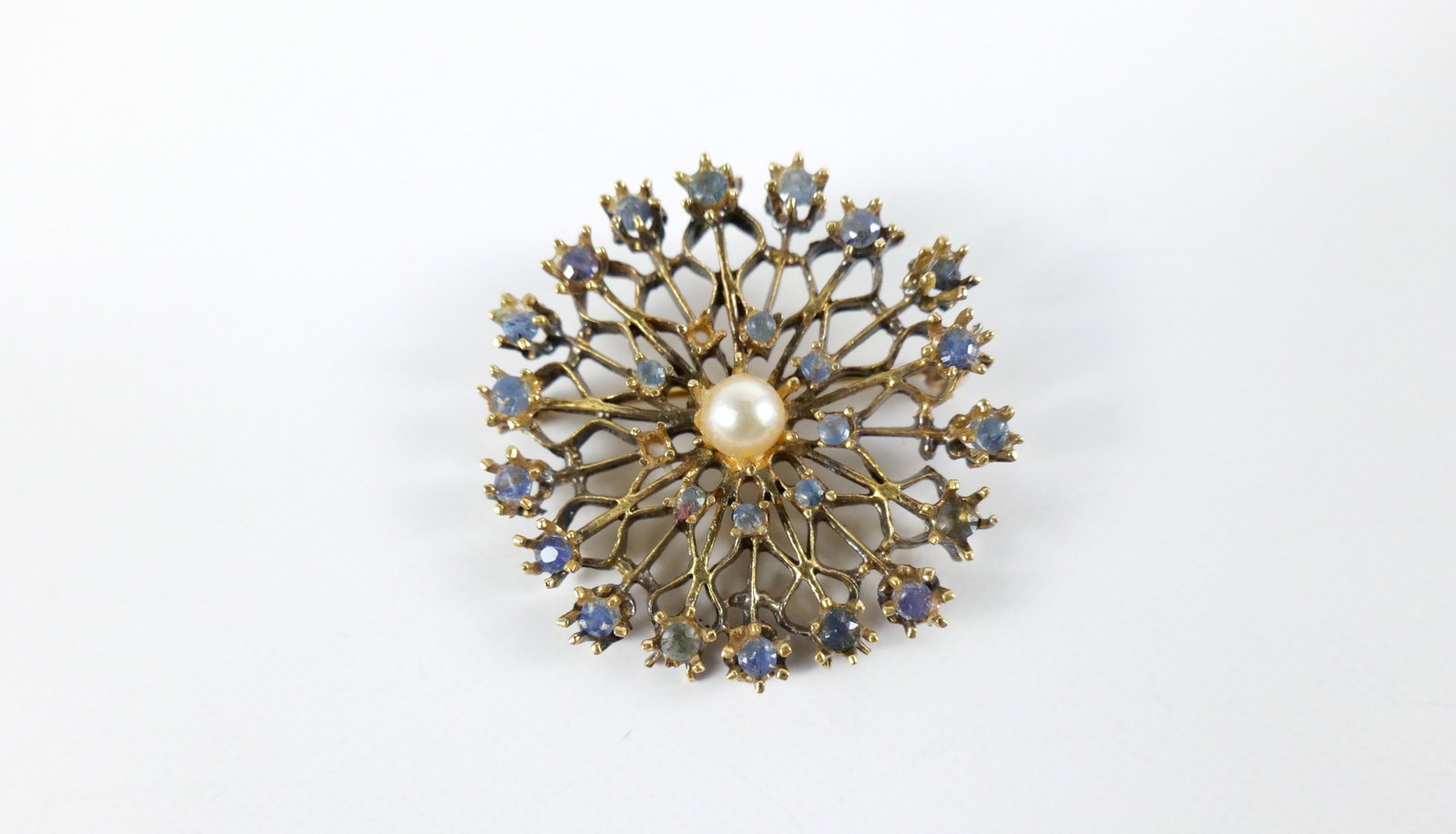 Gold Vermeil and Cultured Pearl Brooch: Gold Vermeil and Cultured Pearl Brooch. The lot includes a vintage 1.15'' round mid-century gold vermeil brooch featuring a gold vermeil snowflake-like brooch with glued 3.5mm and 2mm round blue sapph
