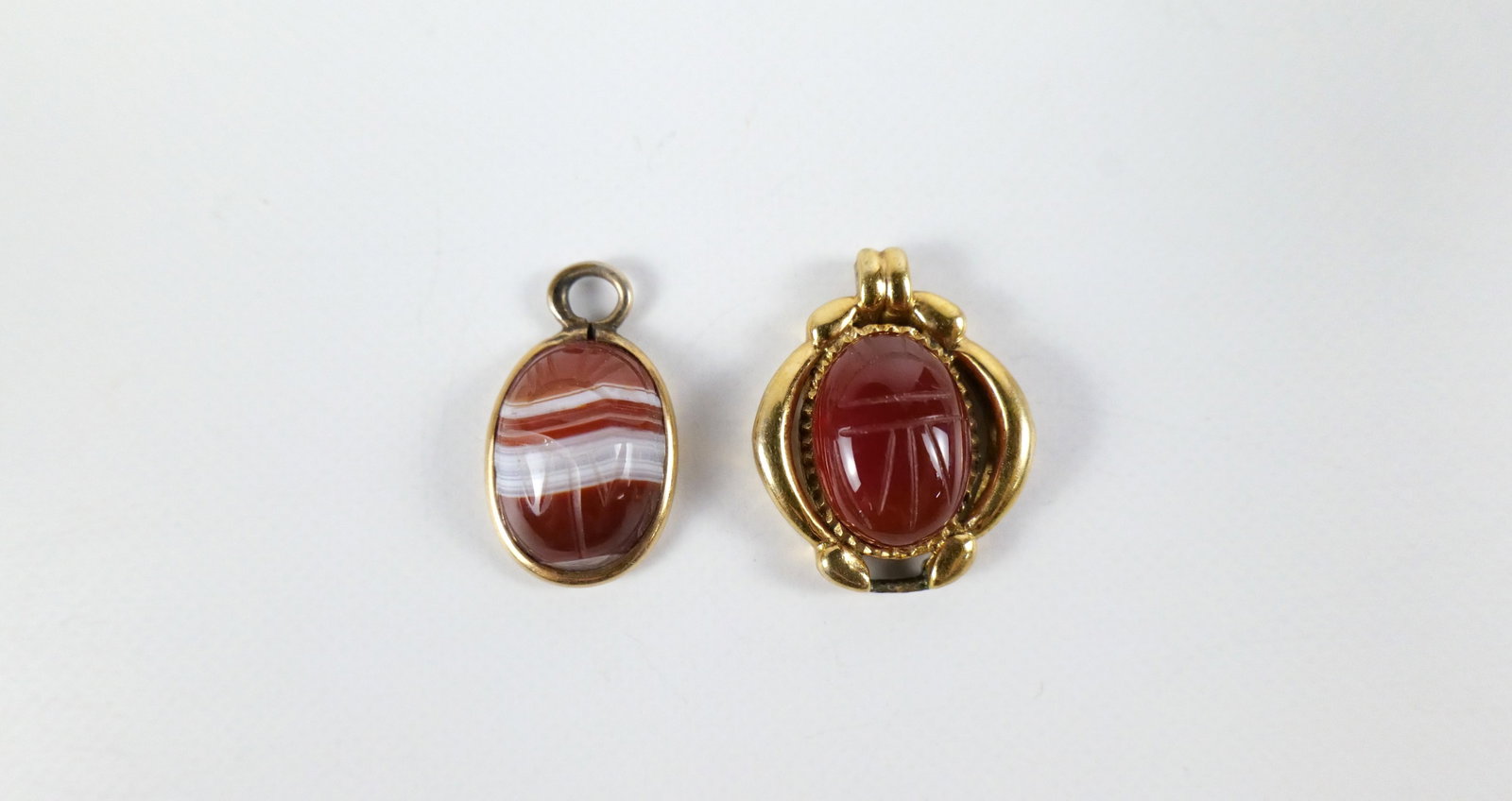 Pair of Vintage Gemstone Scarab Pendants: Pair of Vintage Gemstone Scarab Pendants. The lot includes a pair of vintage scarab pendants. Featuring a vintage .92'' x .73'' gold vermeil pendant set with a 14mm x 10mm carved carnelian oval scarab