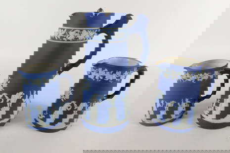 Lot of 3 Wedgwood Cobalt Blue Pitchers: Lot of 3 Wedgwood Cobalt Blue Pitchers. One has silverplated lid - has small chip and glue residue by lid edge. All depicting sacrificial Grecian scenes. Largest measures 7.75" tall. All invoices must