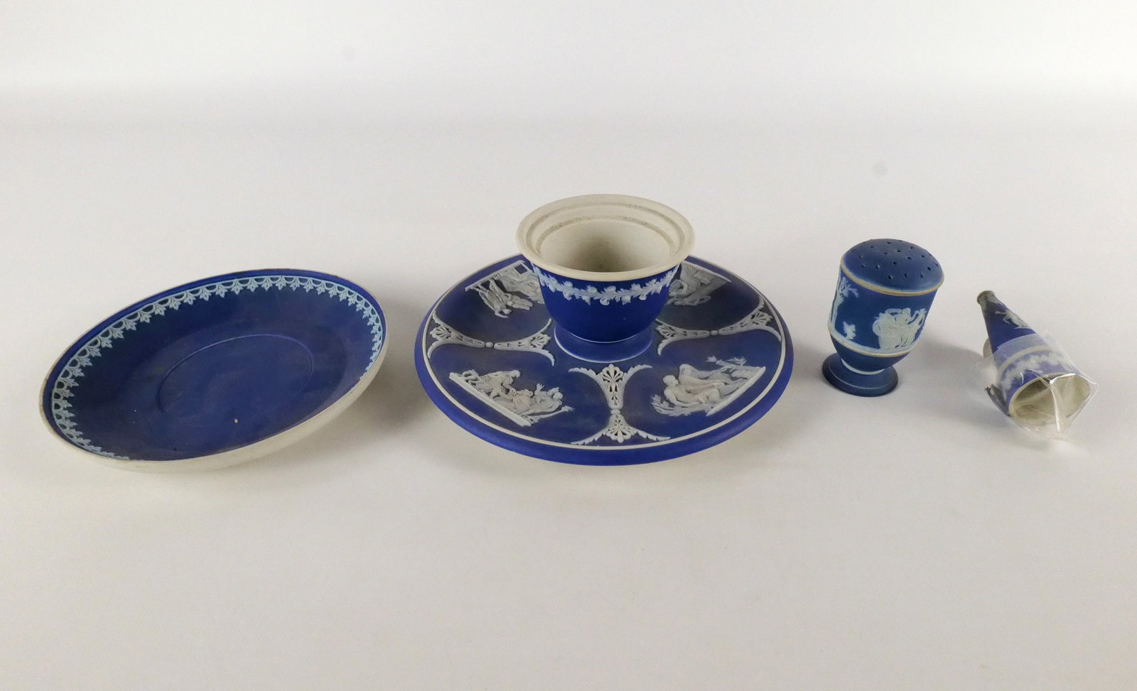 Lot of 4 Wedgwood Cobalt Jasperware Pieces: Lot of 4 Wedgwood Cobalt Jasperware Pieces. Including Saucer, Salt Shaker, Candle Snuffer - AS-IS, and Condiment - Missing Lid. Largest measures 3" tall x 6.5" wide. All invoices must be paid within 2