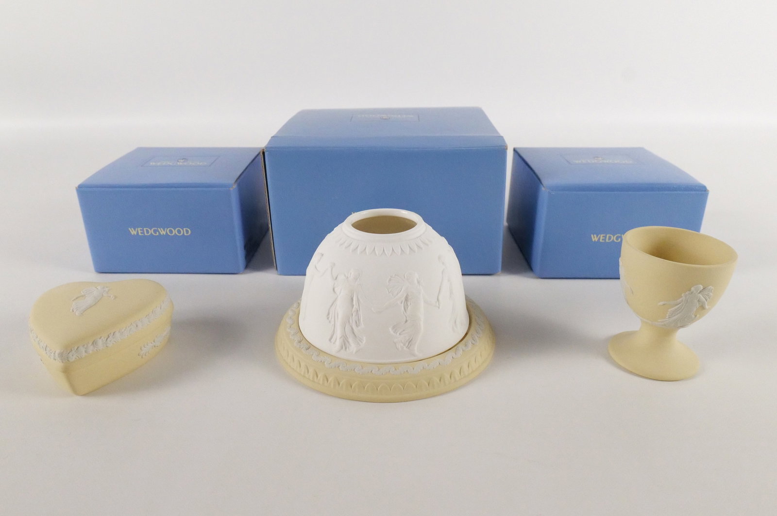Lot of 3 Wedgwood Primrose Yellow Jasperware Dancing Hours Pieces: Lot of 3 Wedgwood Primrose Yellow Jasperware Dancing Hours Pieces. Including Lithophane Tealight Candle Holder measuring 3" tall, Heart Shaped Trinket Box measures 2.75" long, and Egg Cup measuring 2.