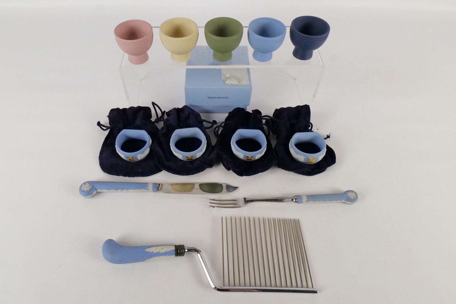 Lot of Wedgwood Jasperware Kitchen Items: Lot of Wedgwood Jasperware Kitchen Items. Including Set of 4 Pale Blue Holiday Napkin Rings with Box, Set of 5 Egg Cups - Light Blue, Cobalt, Sage, Primrose, and Pink, Angel Food Cake Cutter, and Serv
