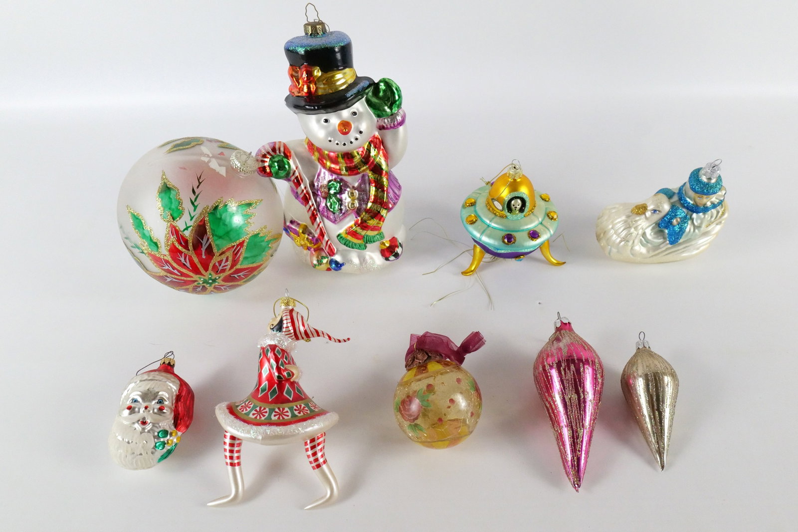 Lot of Glass Ornaments: Lot of Glass Ornaments. Including Snowman, Poinsettia, UFO Spaceship Alien, Teardrops, Ice Queen with Swan and More. Largest measures 9.5" tall. All invoices must be paid within 24 hours of the sale. 