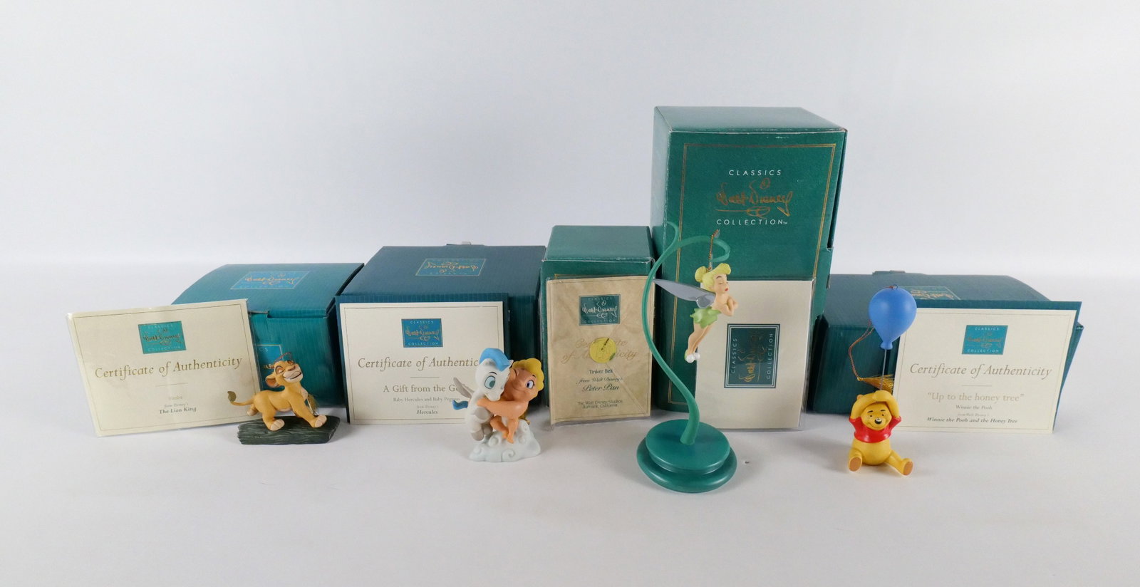 Lot of 4 WDCC Ornaments: Lot of 4 WDCC Ornaments. Including Tinker Bell Ornament with Stand, Simba "Hukuna Matata", "A Gift from the Gods" - Baby Hercules and Pegasus, and "Up the Honey Tree" - Winnie the Pooh. All come with 