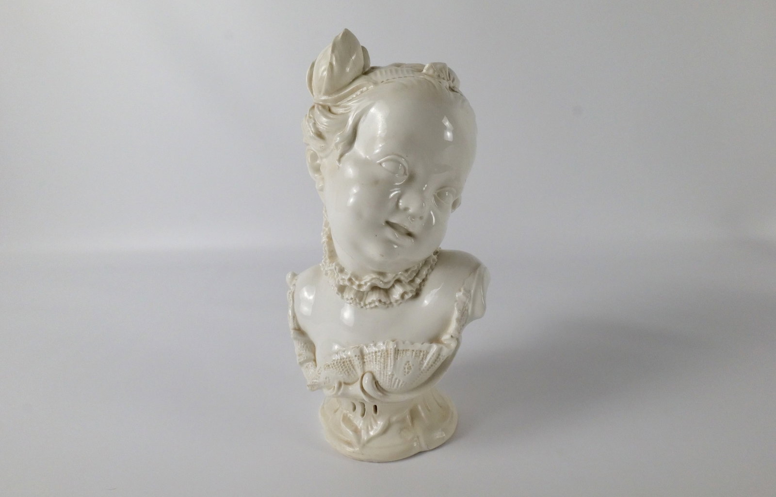 Early 19th Century Nymphenburger Porcelain Bust: Early 19th Century Nymphenburger Porcelain Bust. Depicting a Bust of a Girl. Has some crazing scratches, a small repair on the backside, and crack on base that does not go all the way through. Measure