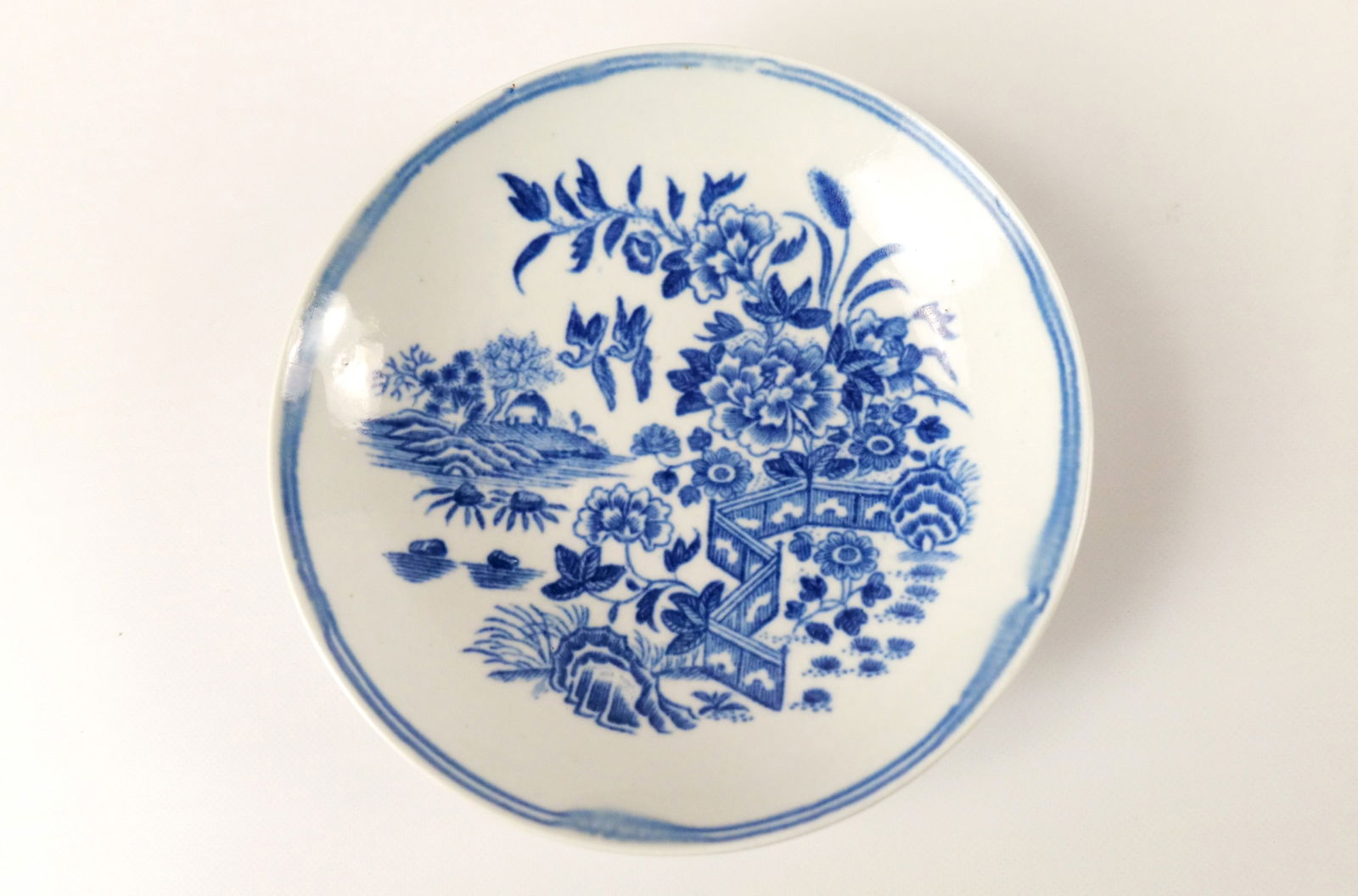 Chinese Export Hand Painted Porcelain Saucer: Chinese Export Hand Painted Porcelain Saucer. At least 18th Century. Blue and White Floral Asian Design. A couple of little chips on the foot rim. Measures 5" diameter. All invoices must be paid withi