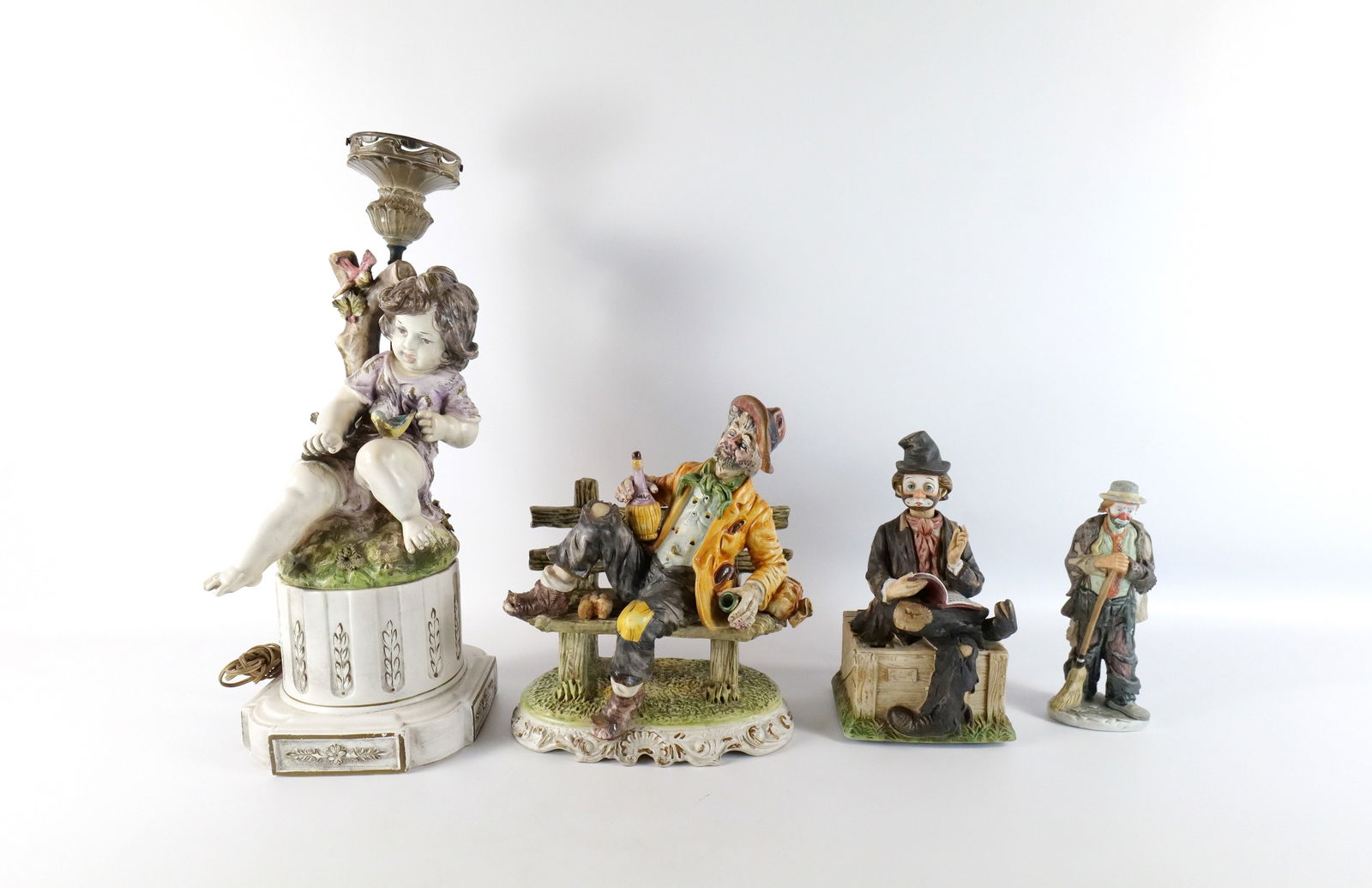 Group Lot of Porcelain Decorative Items: Group Lot of Porcelain Decorative Items. Including Italian Figural Table Lamp - Girl with Birds - Does have breaks on flowers - Chip on Foot, Capodimonte Figurine of Drunk Man on Bench, Waco Battery O