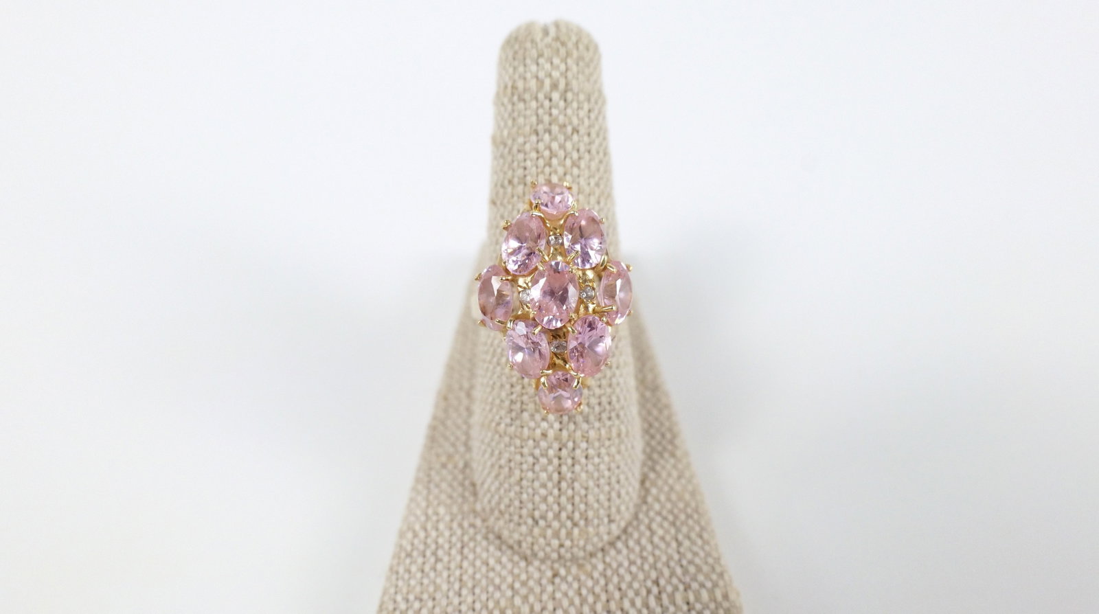 14K Gold and Pink CZ Navette Ring: 14K Gold and Pink CZ Navette Ring. The lot includes a 14K yellow gold domed navette style ring set with nine 7mm x 5mm pink oval CZ's and four white CZ accents. The ring is a sz 9 and has a split shan
