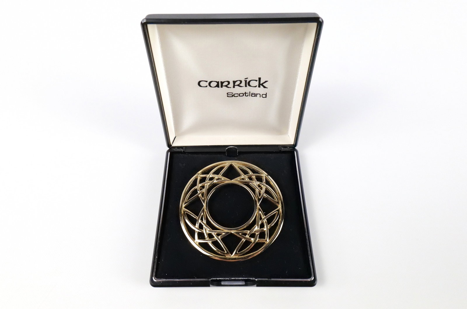 Lochdaw Celtic Knot Wreath Brooch by Carrick: Lochdaw Celtic Knot Wreath Brooch by Carrick. The lot includes a large gold tone Lochdaw Celtic knot wreath brooch by Carrick with a hinged bar closure at the back. It measures 2 3/4'' by 2 3/4'' and 