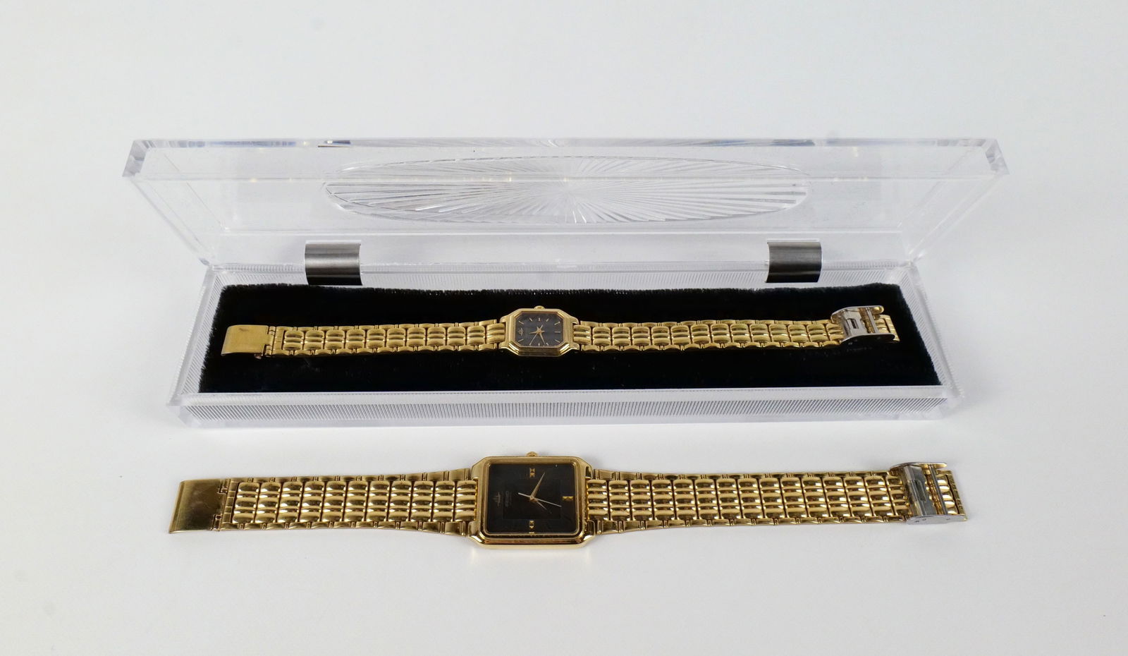 1990s Men's and Women's Matching Quartz Watches by Seiko: 1990s Men's and Women's Matching Quartz Watches by Seiko. The lot includes a vintage 90s pair of men's and ladies gold tone quartz watches by Seiko. Both watches feature black faces with gold tone sti