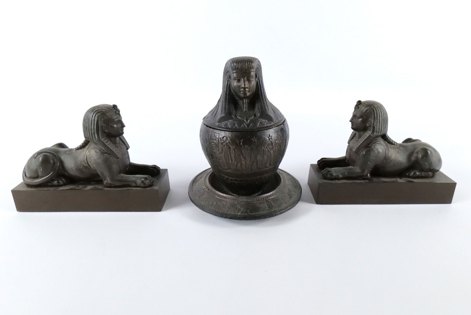 Group Lot of Egyptian Themed Items: Group Lot of Egyptian Themed Items. Including Cast Iron Canopic Jar, and a Pair of Bronze Bookends. Largest measures 8" tall. All invoices must be paid within 24 hours of the sale. We offer multiple s
