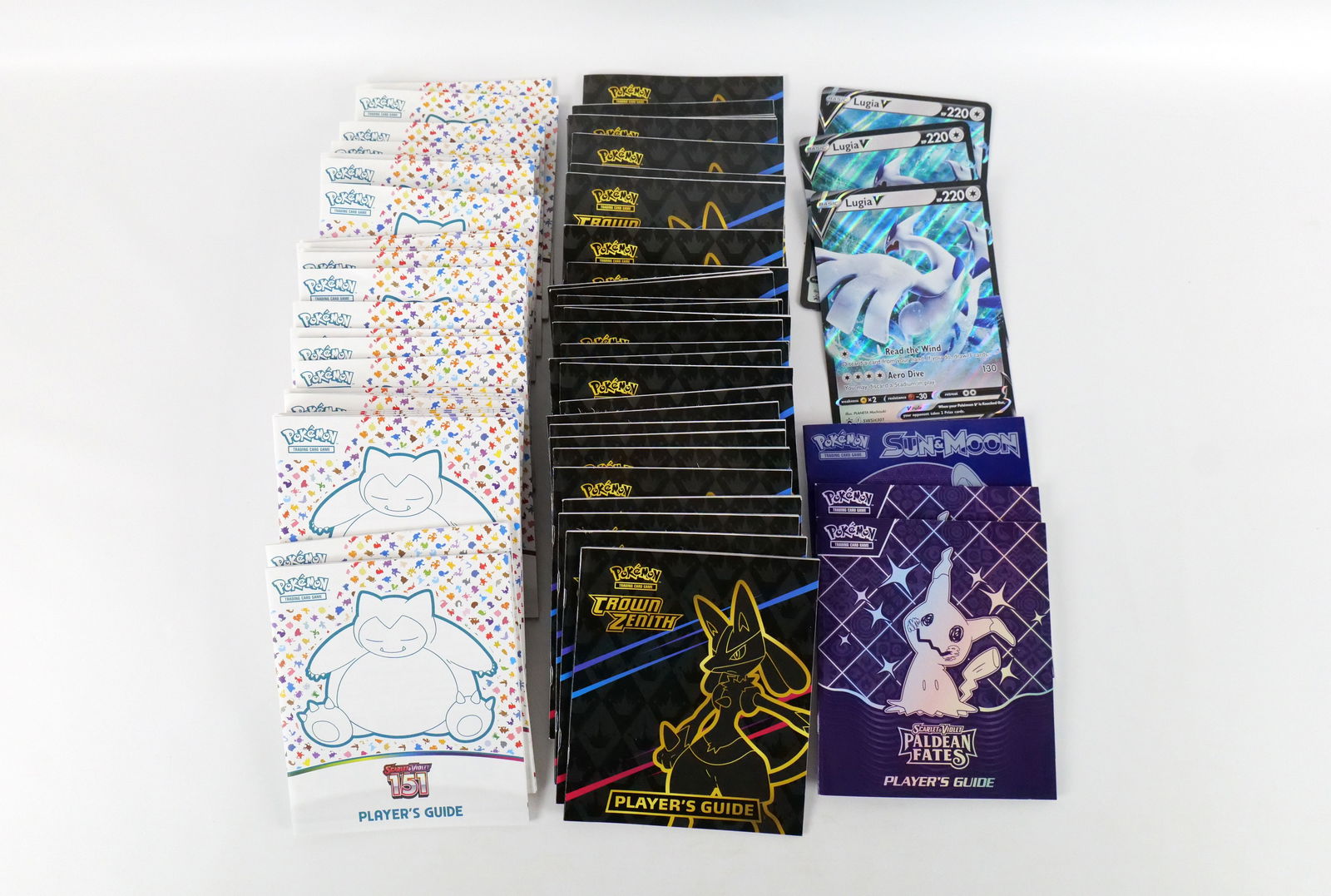 Lot of Pokémon Player's Guides: Lot of Pokémon Player's Guides. Including (28) Scarlet & Violet 151, (30) Crown Zenith, (2) Scarlet & Violet Paldean Fates, Sun & Moon, and Scarlet & Violet Prismatic Evolutions. All invoices must be