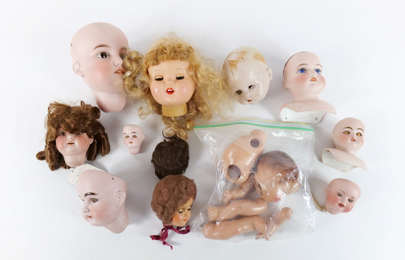 Lot of Doll Heads: Lot of Doll Heads. Vinyl, Composition, Porcelain and Plastic. Antique to Contemporary. Five Antique Bisque Heads Marked Germany. Largest bisque head has cracking. Largest head measures 7.5" long. All