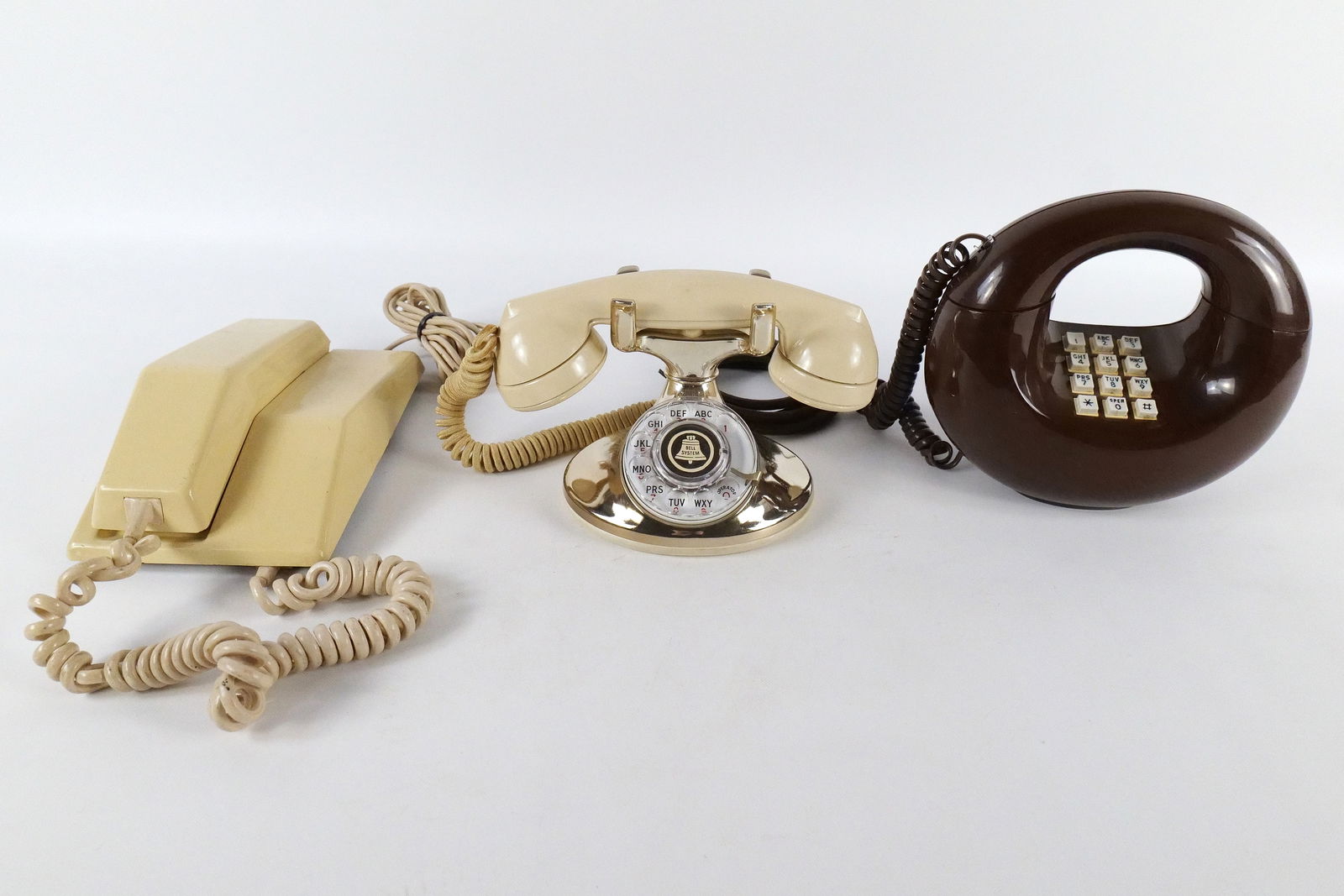 Lot of 3 Vintage Telephones: Lot of 3 Vintage Telephones. Including Northern Electric Contempra Wall Hanging Push Button Telephone, Western Electric Cream and Gold Rotary Telephone, and Brown Unmarked Donut Phone. All invoices mu