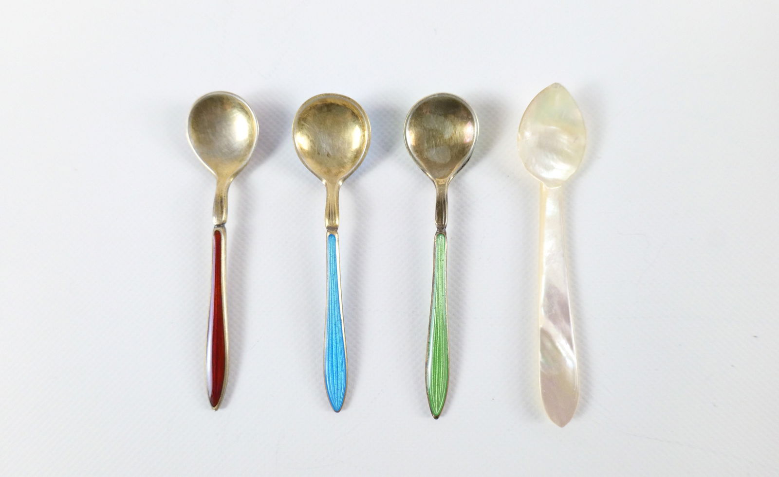 Lot of 4 Salt Spoons: Lot of 4 Salt Spoons. Including 3 Sterling and Enamel and one Mother of Pearl. The sterling spoons weigh approx. 11.6 grams. All invoices must be paid within 24 hours of the sale. We offer multiple