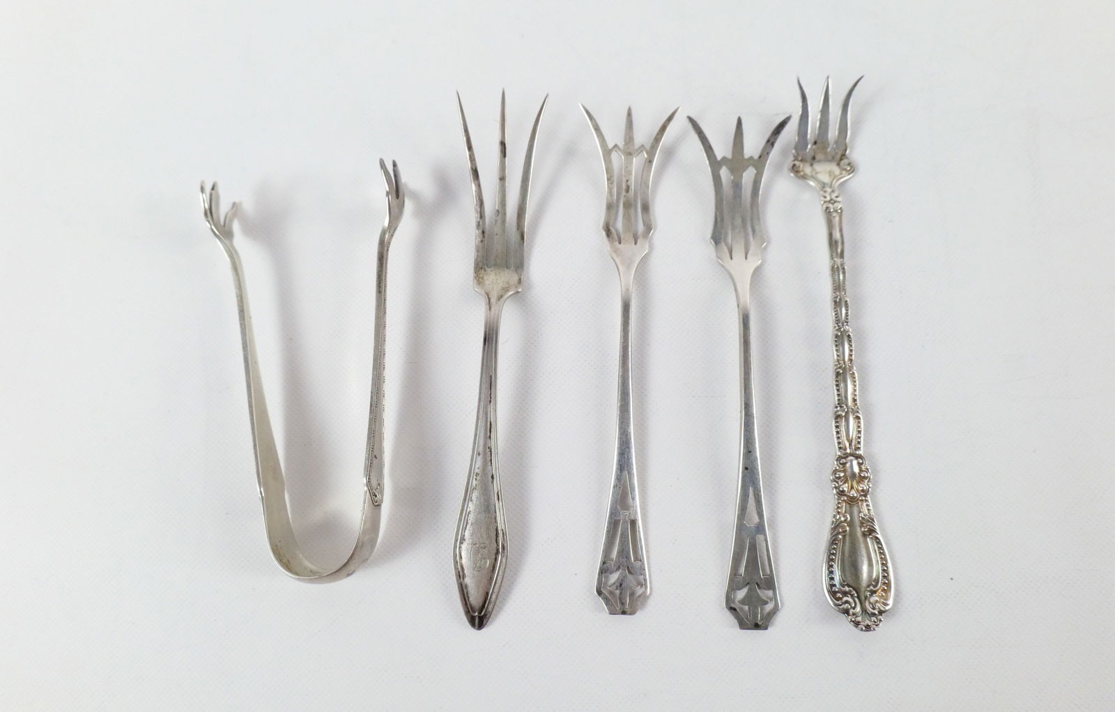 Lot of 5 Sterling Silver Serving Pieces: Lot of 5 Sterling Silver Serving Pieces. Including Small Tongs and 4 x Lemon Forks. Largest measures 5.25" long. Weighs approx. 63.2 grams. All invoices must be paid within 24 hours of the sale. We