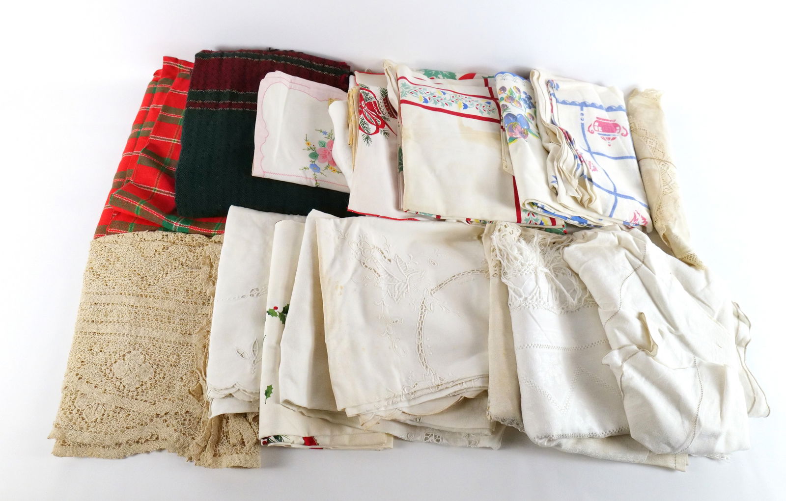 Lot of Vintage Tablecloths and Runners: Lot of Vintage Tablecloths and Runners. Including Holiday Green and Red, Holiday Holly Leaf, Embroidered, Pink and White Floral, Lace, and More. All could use a cleaning as staining is present. All in