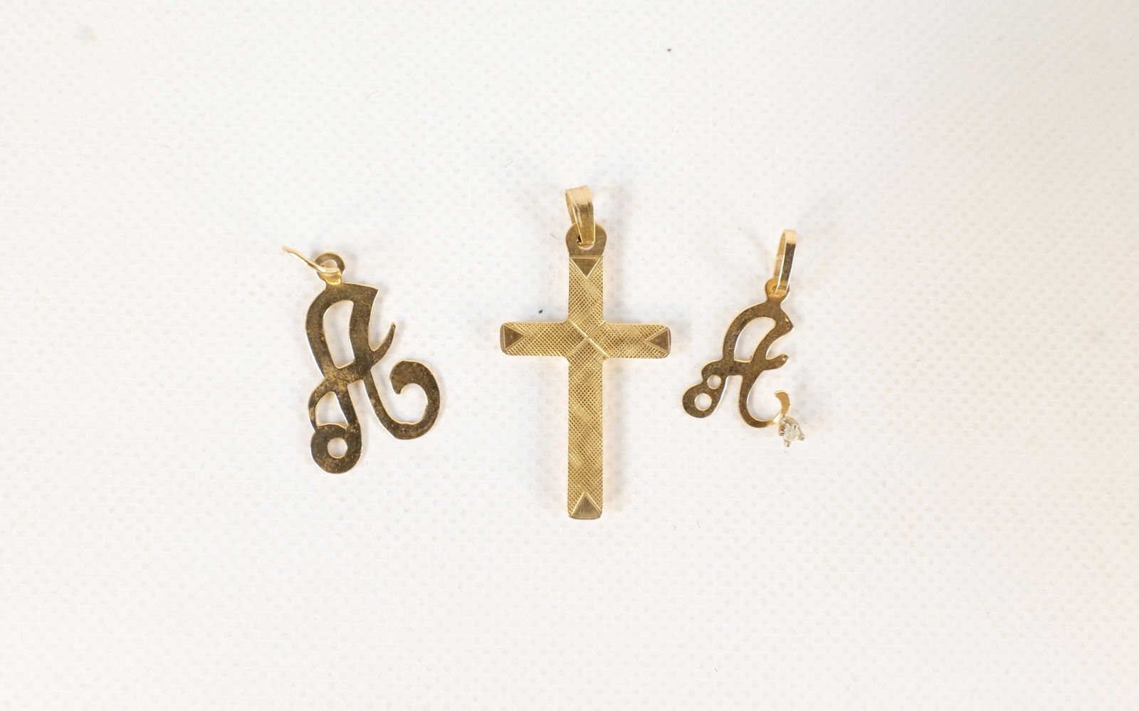 Lot of 3 14k Gold Charms: Lot of 3 14k Gold Charms. Two are letter A - One set with stone and other is cross pendant measuring 1". Weighs approx. 1.5 grams. All invoices must be paid within 24 hours of the sale. We offer multi