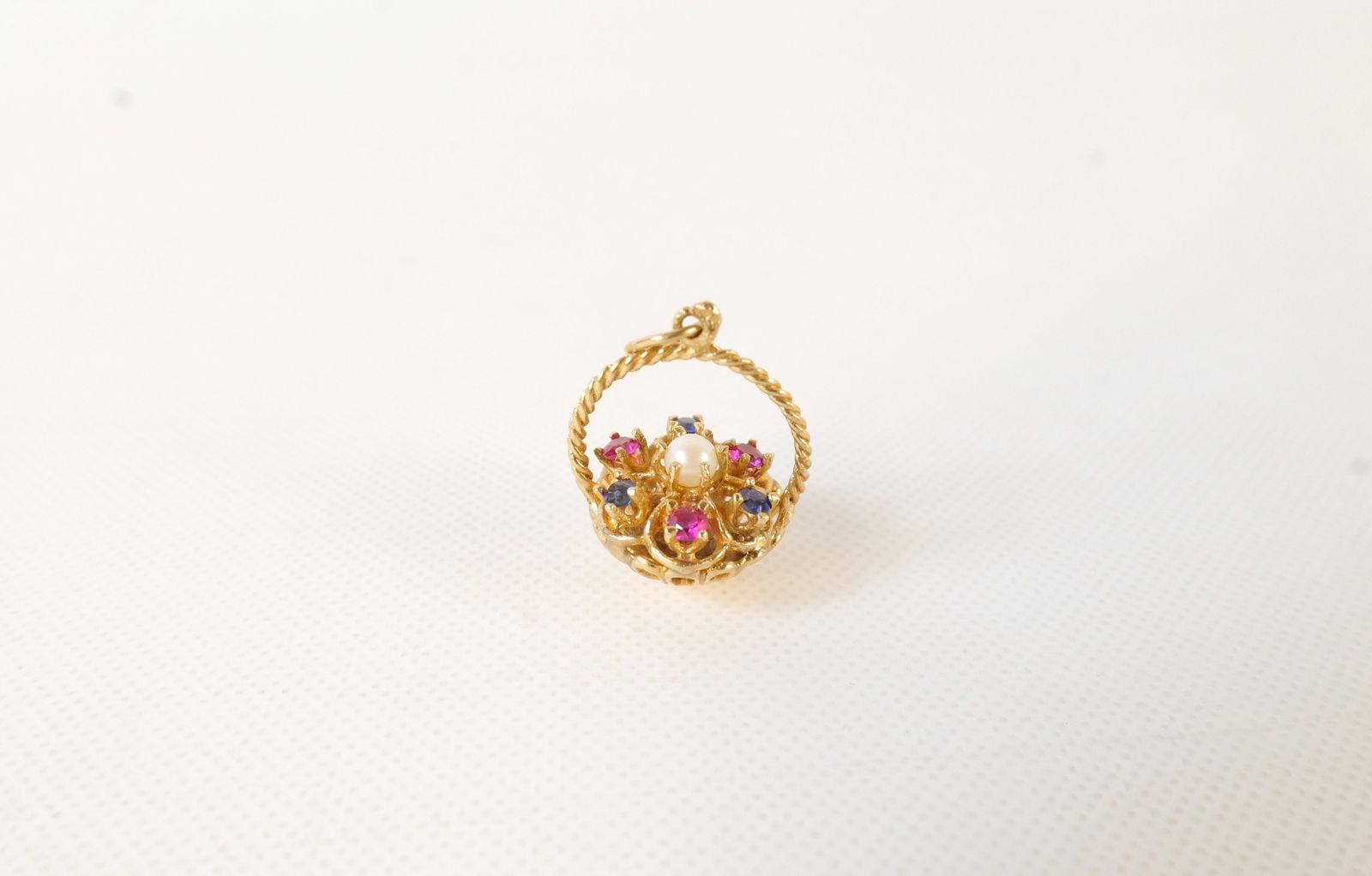 14k Basket Charm: 14k Basket Charm. Set with Sapphire, Rubies, and Seed Pearl. All invoices must be paid within 24 hours of the sale. We offer multiple shipping options, please read the shipping terms to understand