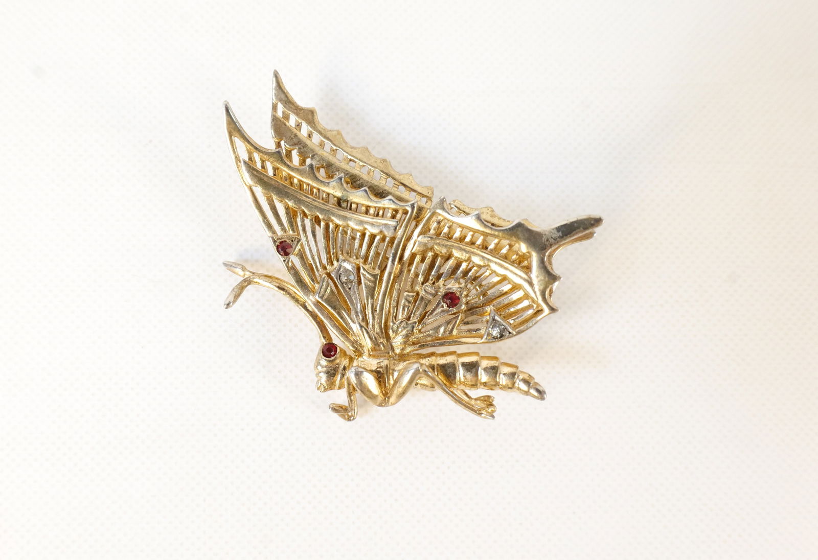 Vintage Unsigned DeRosa Gold Plated Sterling Silver Butterfly Brooch: Vintage Unsigned DeRosa Gold Plated Sterling Silver Butterfly Brooch. Set with Clear and Red Rhinestones. Measures 2" tall. All invoices must be paid within 24 hours of the sale. We offer multiple shi