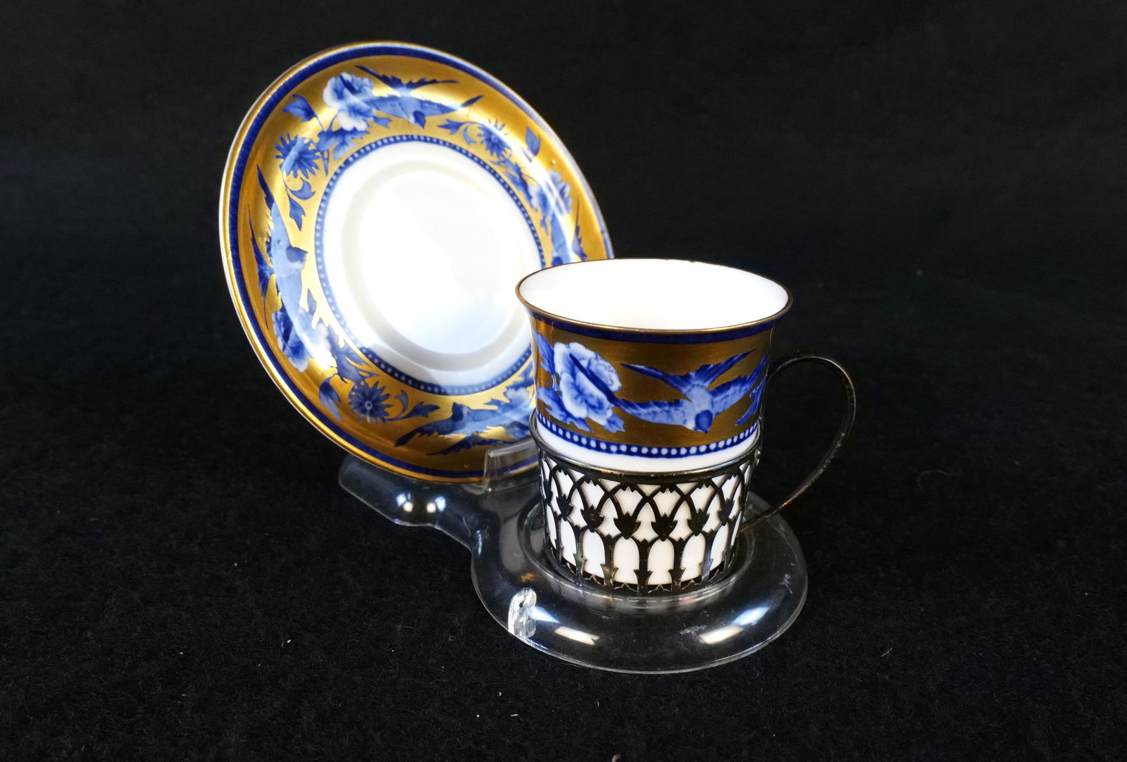 Shelley Bone China Demitasse Cup with Underplate: Shelley Bone China Demitasse Cup with Underplate. Cup has a Sterling Openwork Handled Holder. Hallmarked on Bottom. Good Condition. All invoices must be paid within 24 hours of the sale. We offer mult