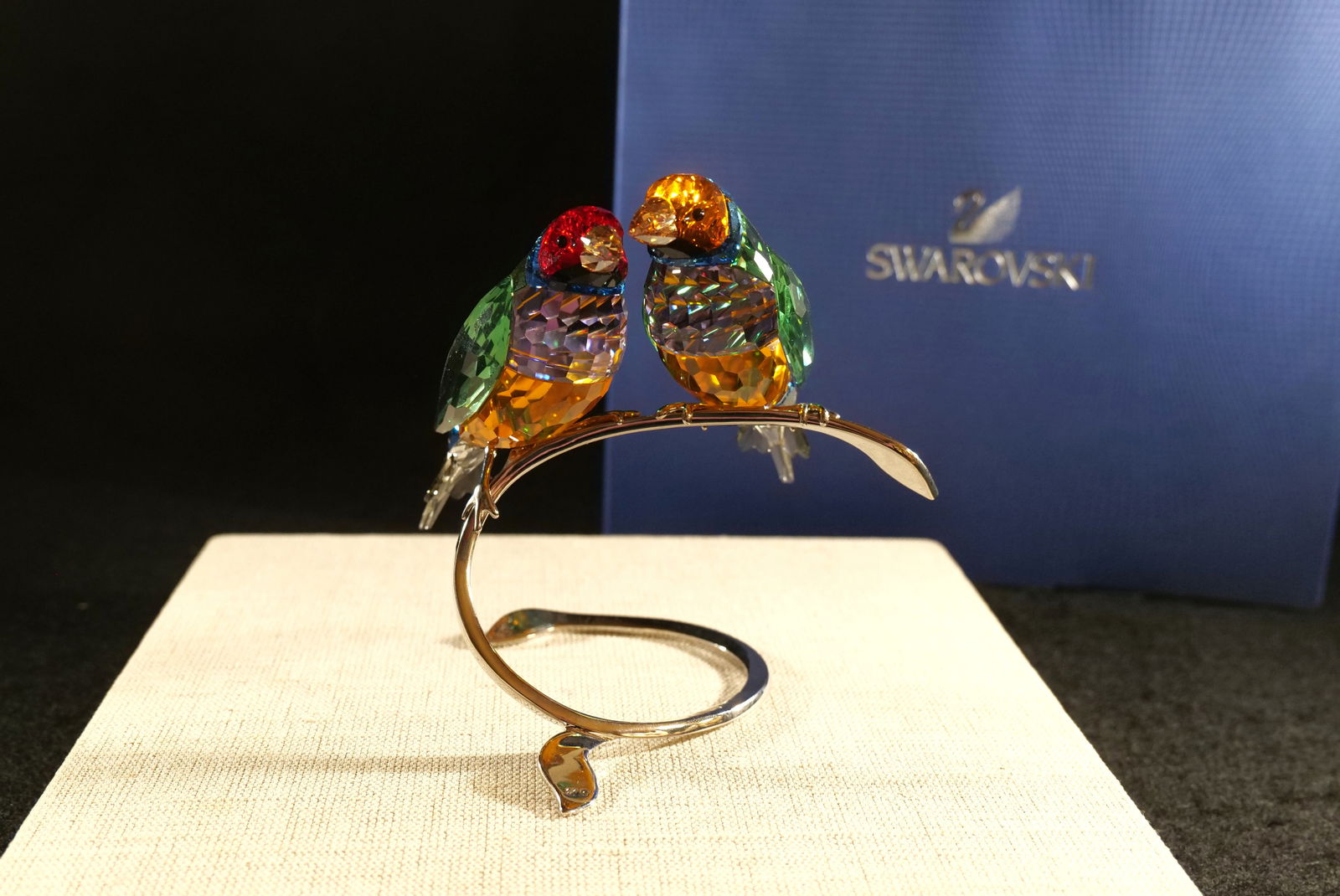 Swarovski Crystal Peridot Gouldian Finches Figurine: Swarovski Crystal Peridot Gouldian Finches Figurine. Paradise Birds Collections. They come perched on a silver metal stand. Stunning colors of green, blue, red, smoke, orange, and purple. Measures 5"