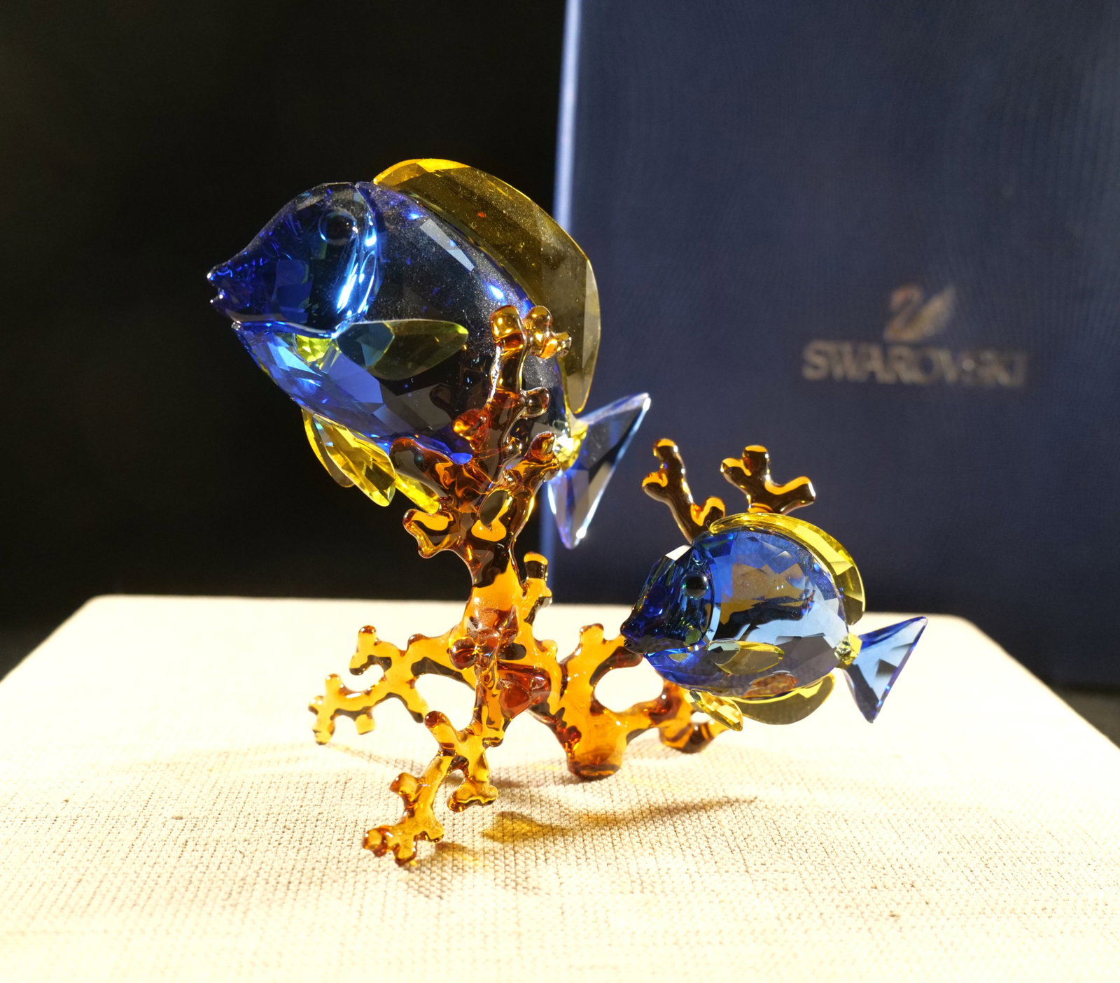 Swarovski Crystal Doctorfish Figurine: Swarovski Crystal Doctorfish Figurine. Blue and Yellow Colored Crystal Fish on Amber Colored Crystal Coral. Measures 4.5" tall x 5" wide. Comes with box. All invoices must be paid within 24 hours of t