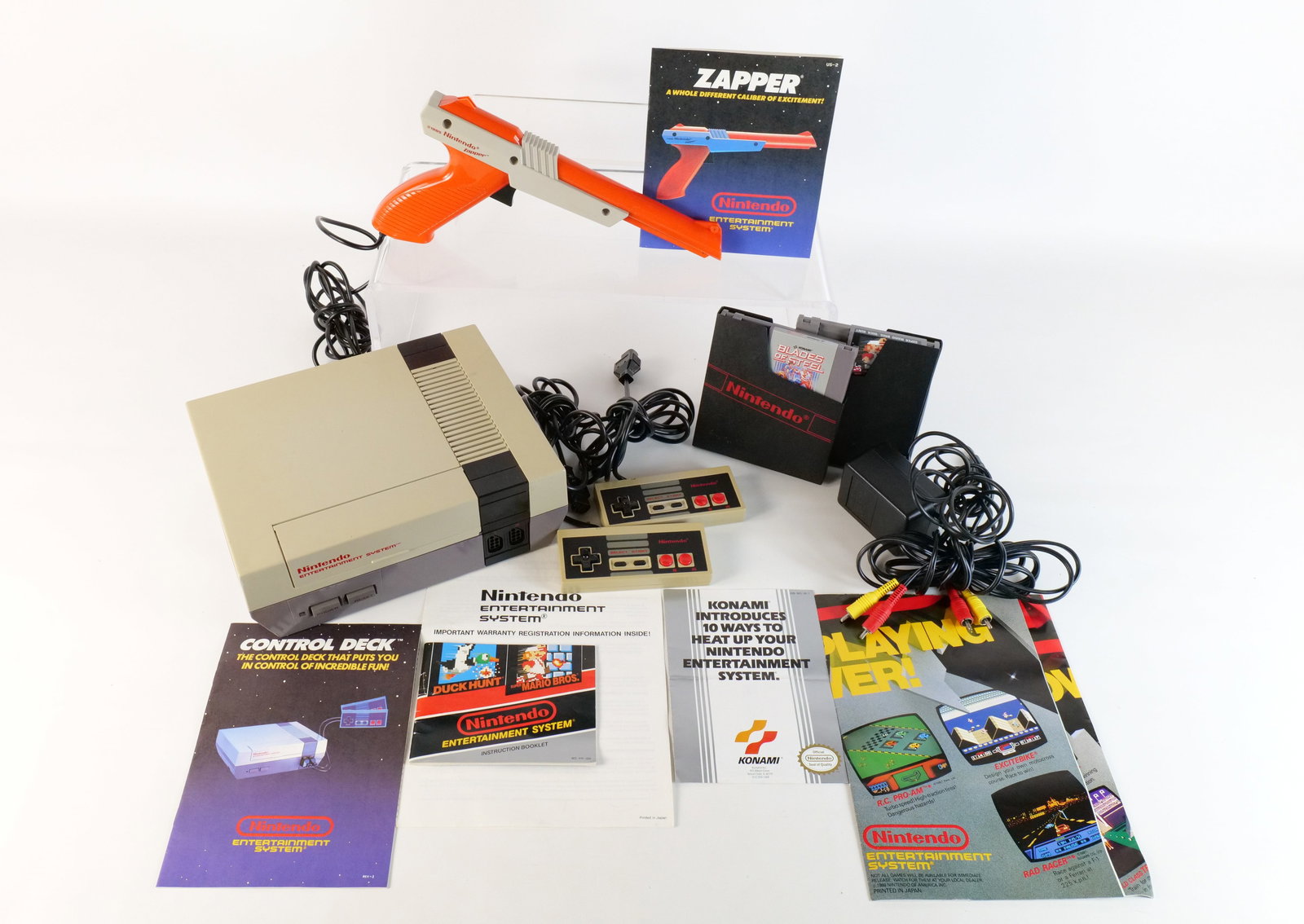 Nintendo NES Lot: Nintendo NES Lot. Including NES System with 2 Controllers, Duck Hunt Gun, Cords and Manual. Also includes Mario Bros/Duck Hunt Game and Blades of Steel Game - Both with Paperwork. Machine was plugged