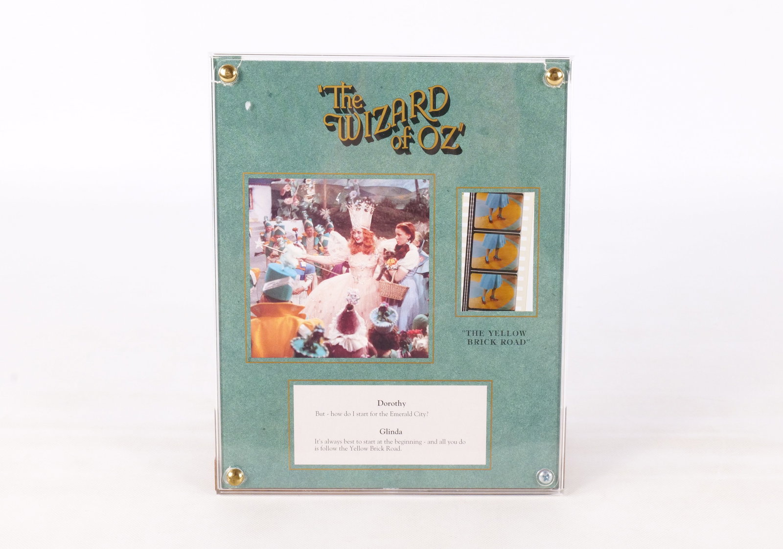Recollections The Wizard of Oz Collage: Recollections The Wizard of Oz Collage. Including Reproduction Movie Cel, Lithograph, and Excerpt from the script. The paper under the frame has tears at the two top edges. All invoices must be paid w