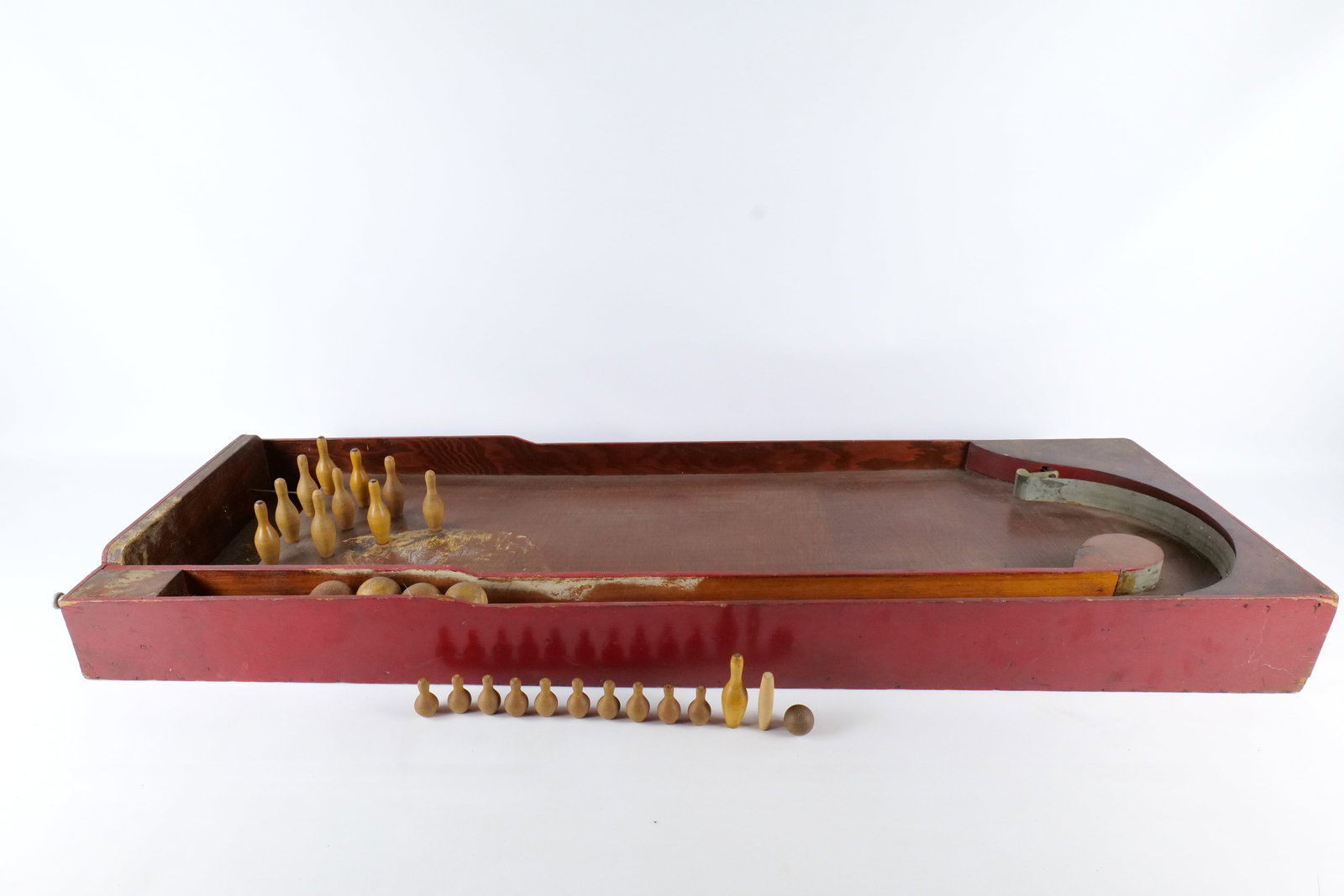Antique Wooden Bowling Bagatelle Game: Antique Wooden Bowling Bagatelle Game - Tabletop Pinball with Pins and Balls. Features original spring loaded plunger and metal guide rail. Comes with pins and balls. Heavy surface wear and finish los
