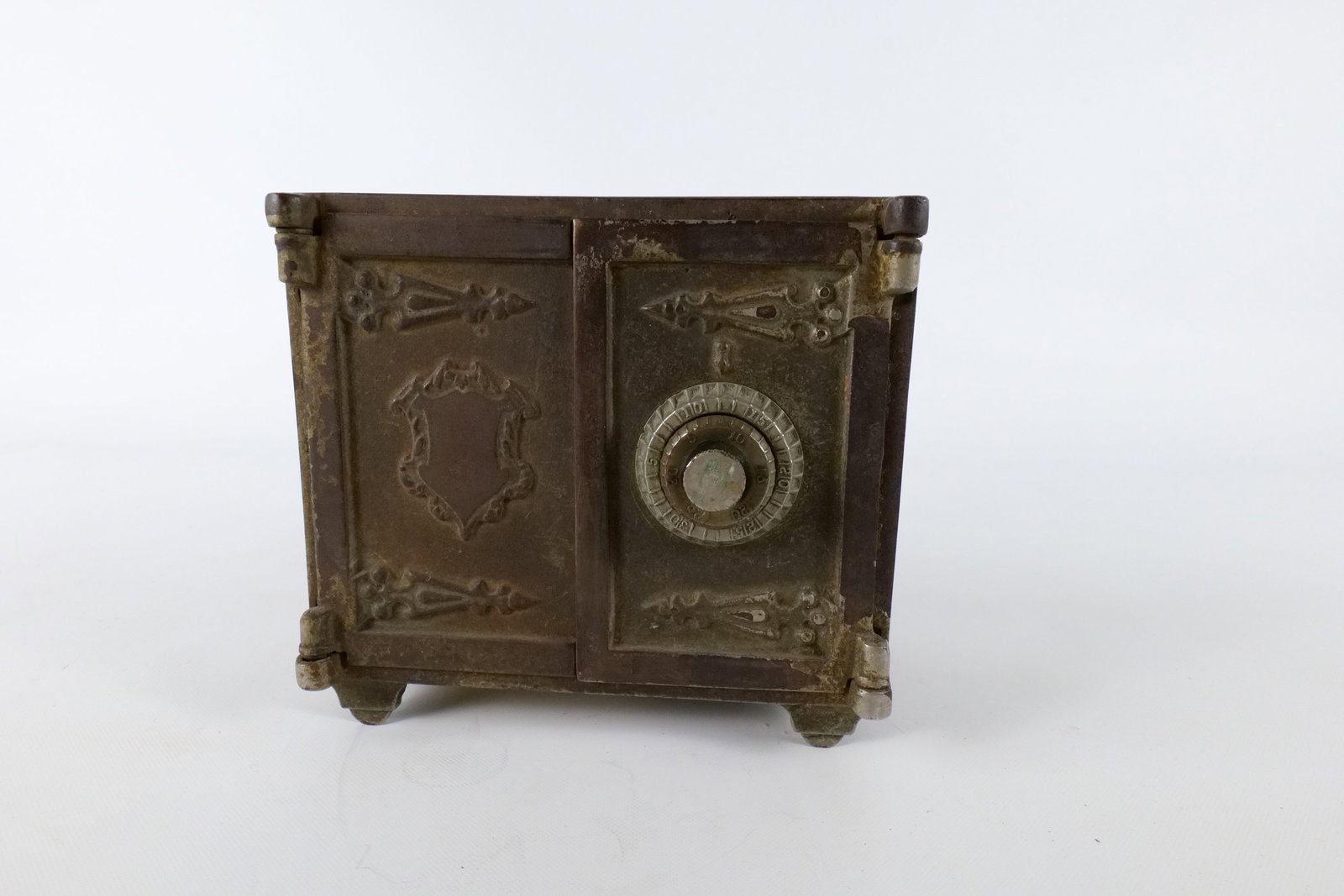 Antique Cast Iron Safe Still Bank: Antique Cast Iron Safe Still Bank with Ornate Scrollwork. Combination Lock is closed. Unsure of code. Age related Patina/Oxidation present. Measures 6" tall x 6.5" wide. All invoices must be paid with