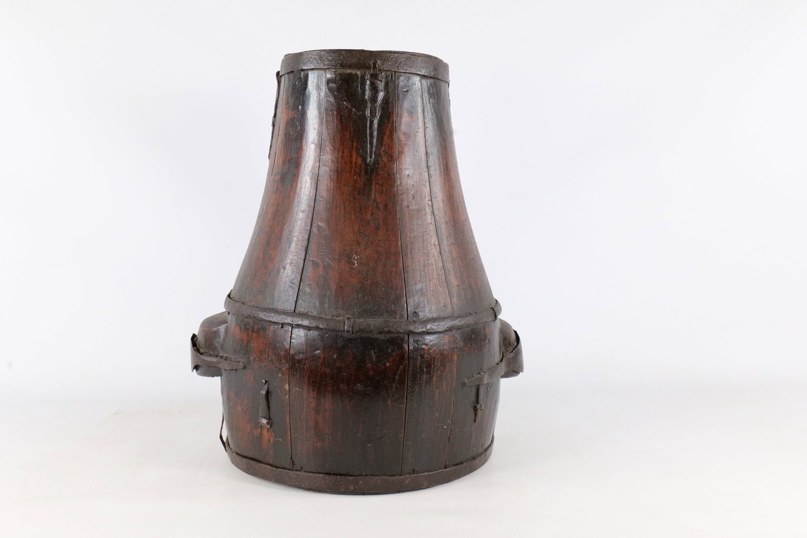 Antique Wooden Stave Constructed Well Bucket: An antique wooden vessel of stave construction, commonly identified as a well bucket or water container. The object features a distinctive form with a tapered upper section resting on a wider