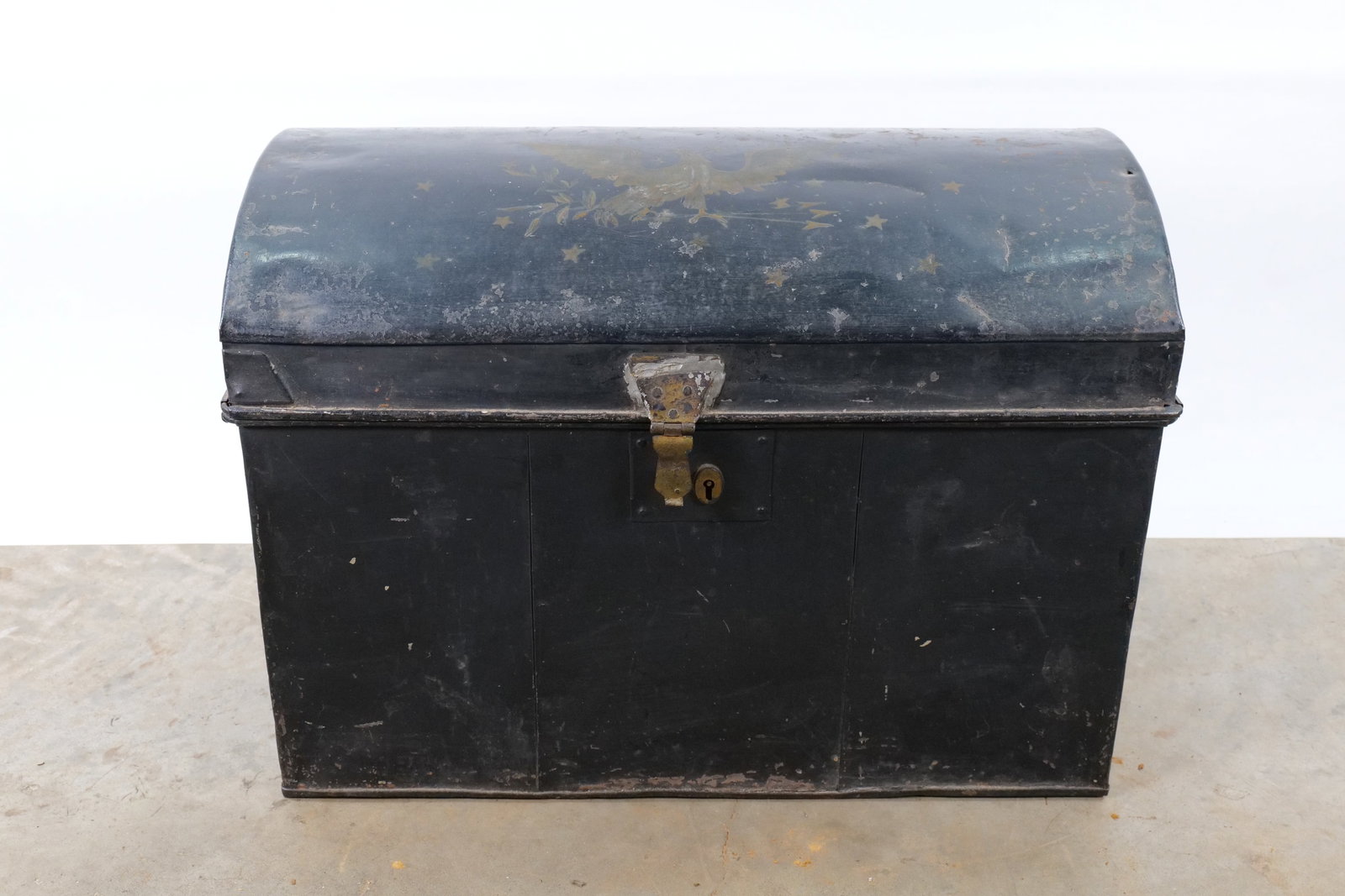 Antique Dome-Top Metal Steamer Trunk - Patriotic Gold Eagle and Stars: An antique American dome-top trunk constructed from sheet metal, likely tin or iron. The exterior features a black painted finish with a hand-painted patriotic motif on the center of the lid. The