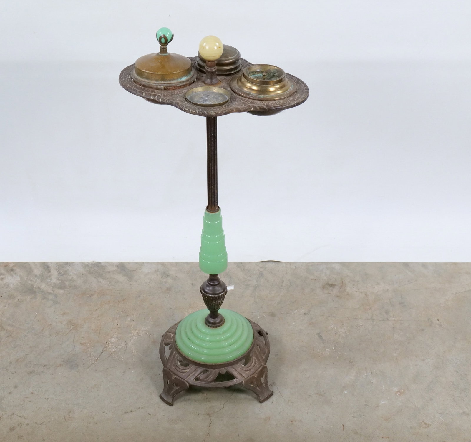 Art Deco Jadeite Glass and Cast Metal Smoking Stand: Art Deco Jadeite Glass and Cast Metal Smoking Stand. Circa 1930's. The top includes a multi-functional tray with a covered tobacco humidor, a matchbox holder/striker, and removable ashtray insert.