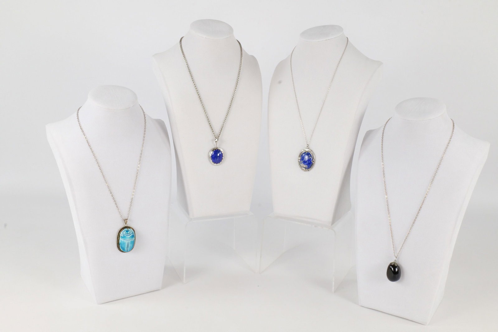 Lot of Sterling Jewelry: Lot of sterling jewelry including a blue faience scarab necklace/pendant, a lapis lazuli necklace/pendant and 2 glass pendants. The necklaces measure approx. between 16" and 20". All invoices must be 