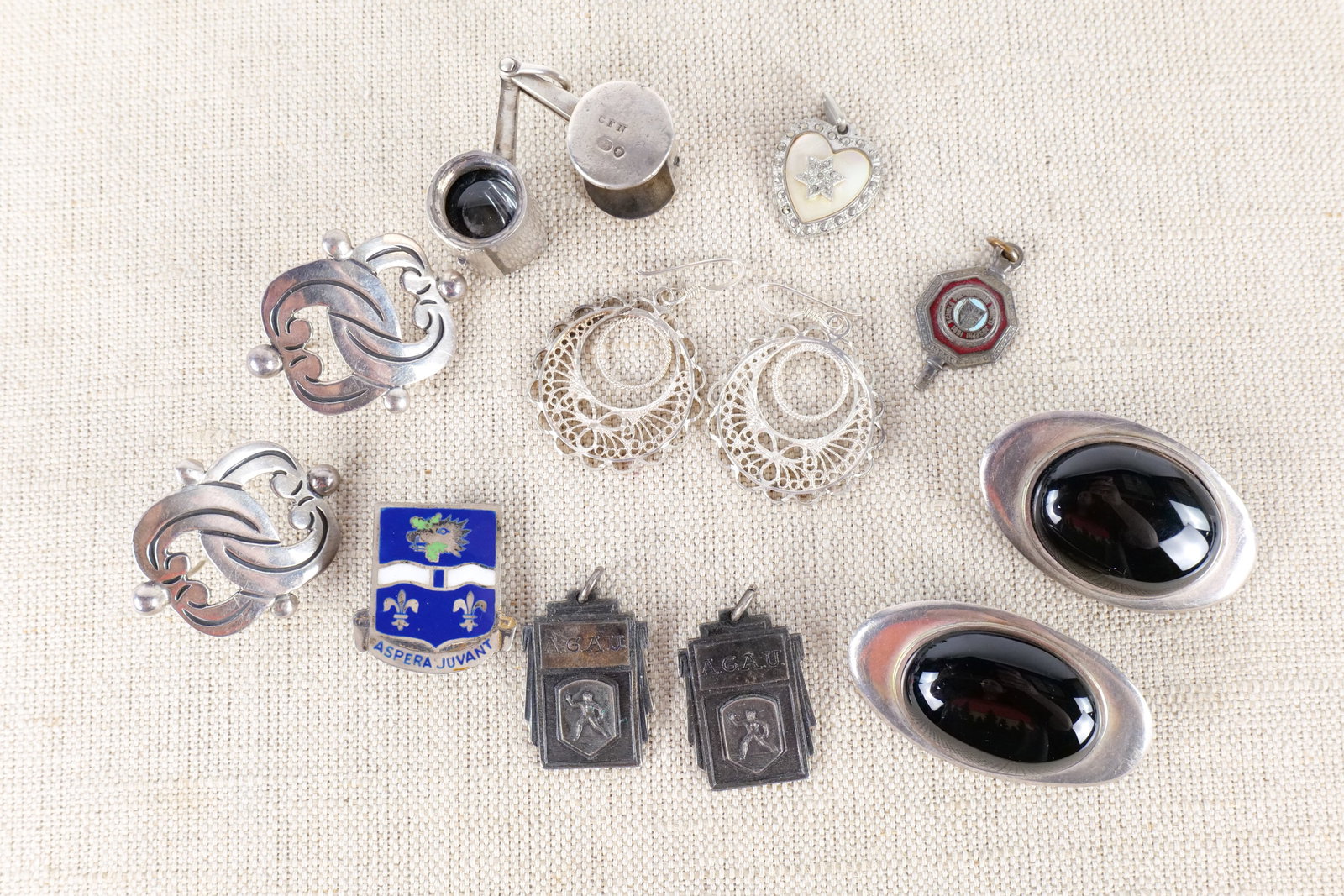 Lot of Sterling Jewelry: A lot of sterling jewelry including large clip earrings with Oval black stones, pierced filigree hoop earrings, modern Mexican silver pierced earrings, an adorable vintage jewelry loop in a sterling