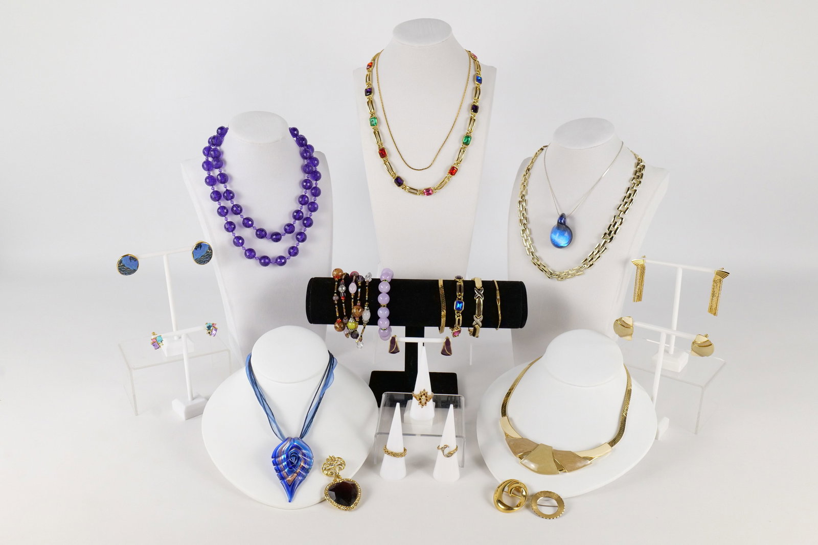 Lot of Costume Jewelry: Lot of assorted costume jewelry including art glass pendants, A braided Avon ring size 7 3/4, a Monet brooch, Trifari necklace and earring set, a simulated Opal ring size 6, a cocktail ring size 8 and