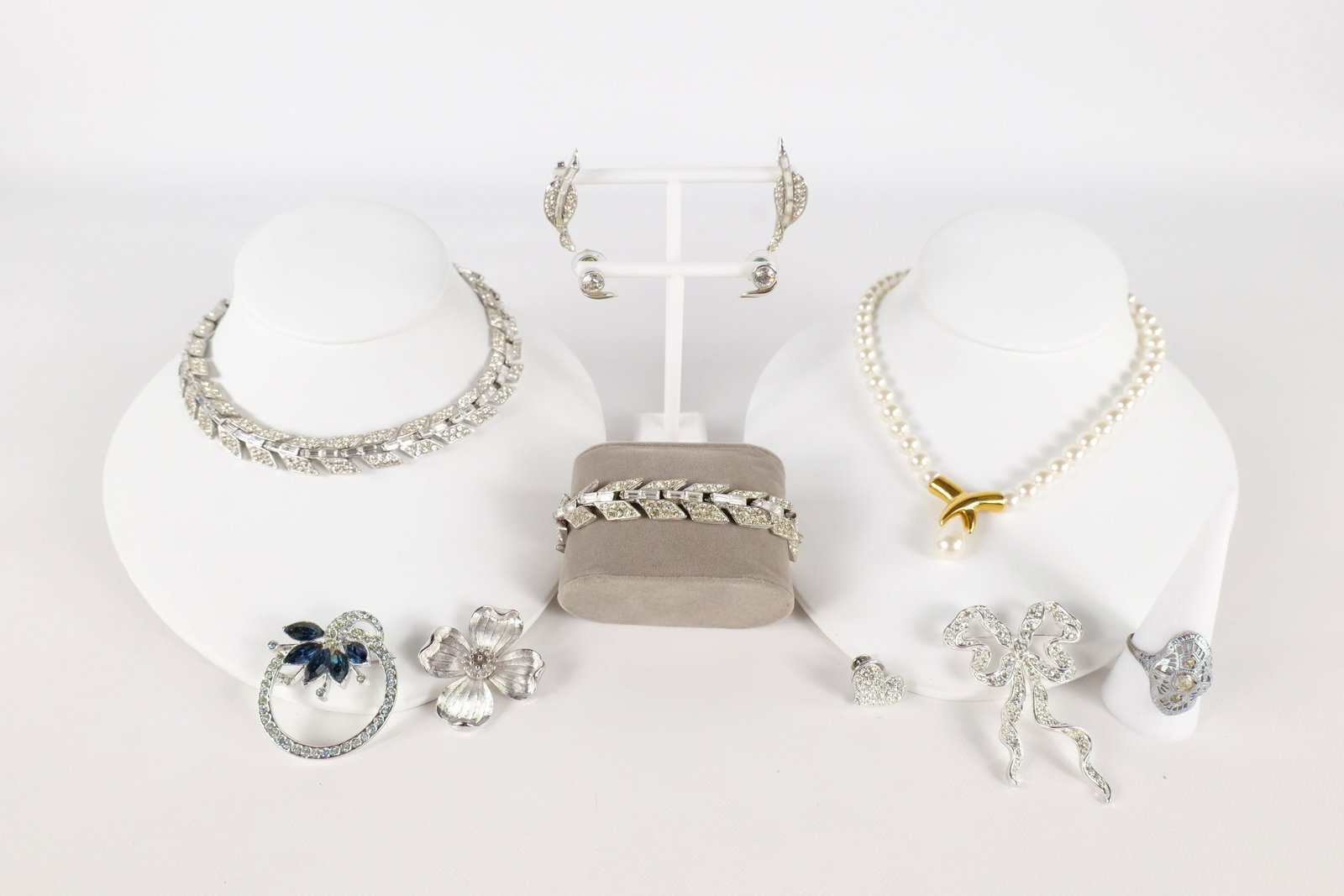 Lot of Costume Jewelry: Lot of assorted costume jewelry including an MMA bow pin, trinary flower, Napier simulated Pearl necklace, Swarovski heart tack pin, Swarovski pierced earrings and more. Ring is a size 10. All invoice