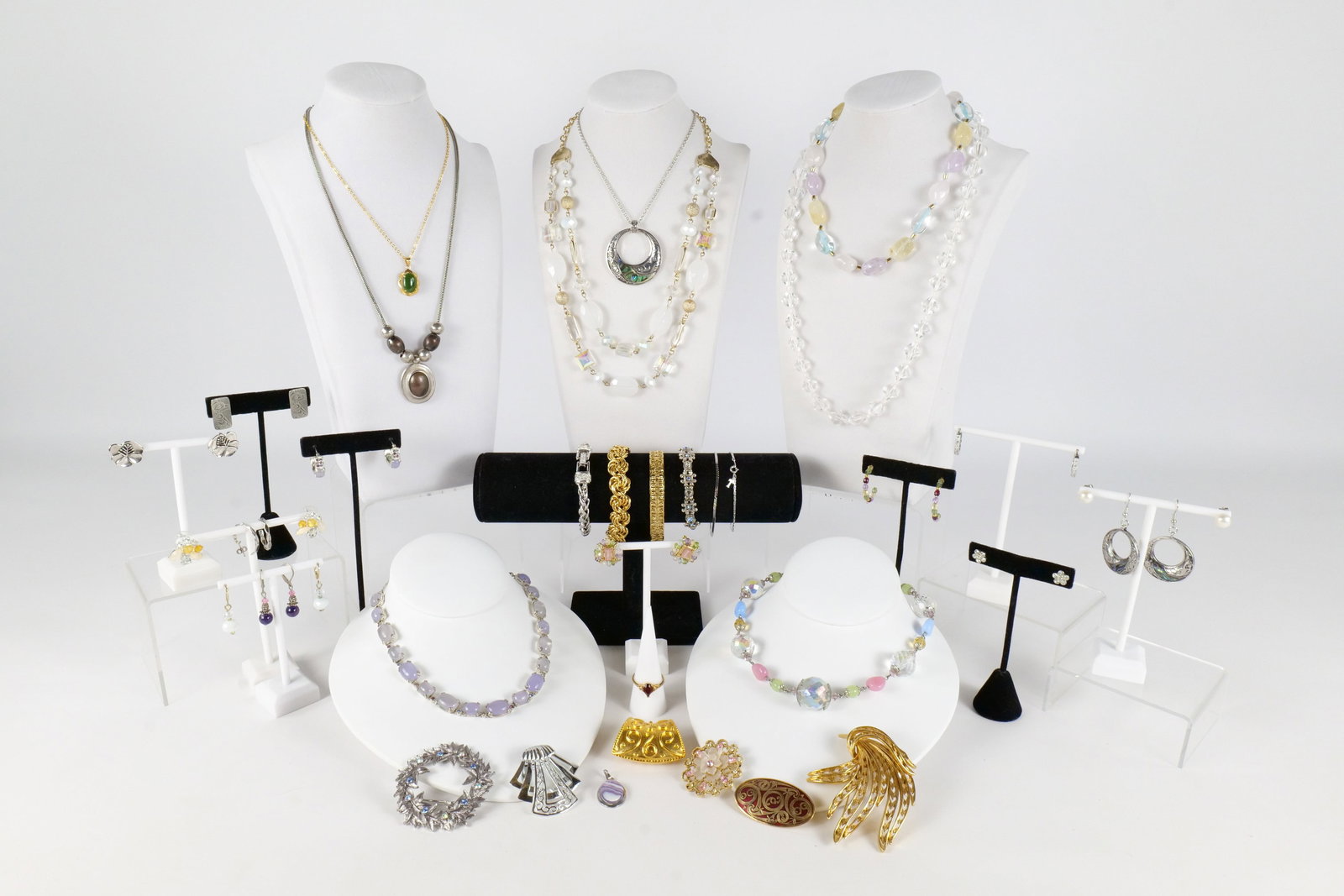 Lot of Costume Jewelry: Lot of costume jewelry including a Monet cabochon necklace and earrings, faceted crystal beaded necklace, cocktail ring with a red stone size 8 3/4, Celtic sea gems enamel brooch, Monet spray brooch, 