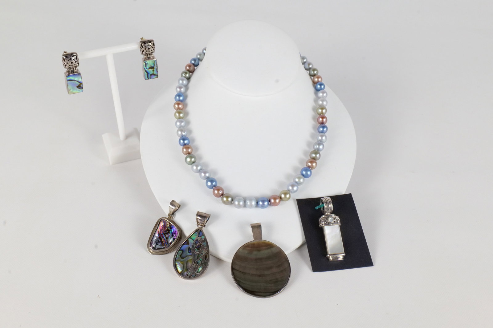 Lot of Sterling Sivler Jewelry: Lot of sterling silver jewelry including a pendant with mother of pearl style stone, Sterling clasped pearls marked MS, a sterling and glass stone pendant, a sterling and abalone pendant and earrings 