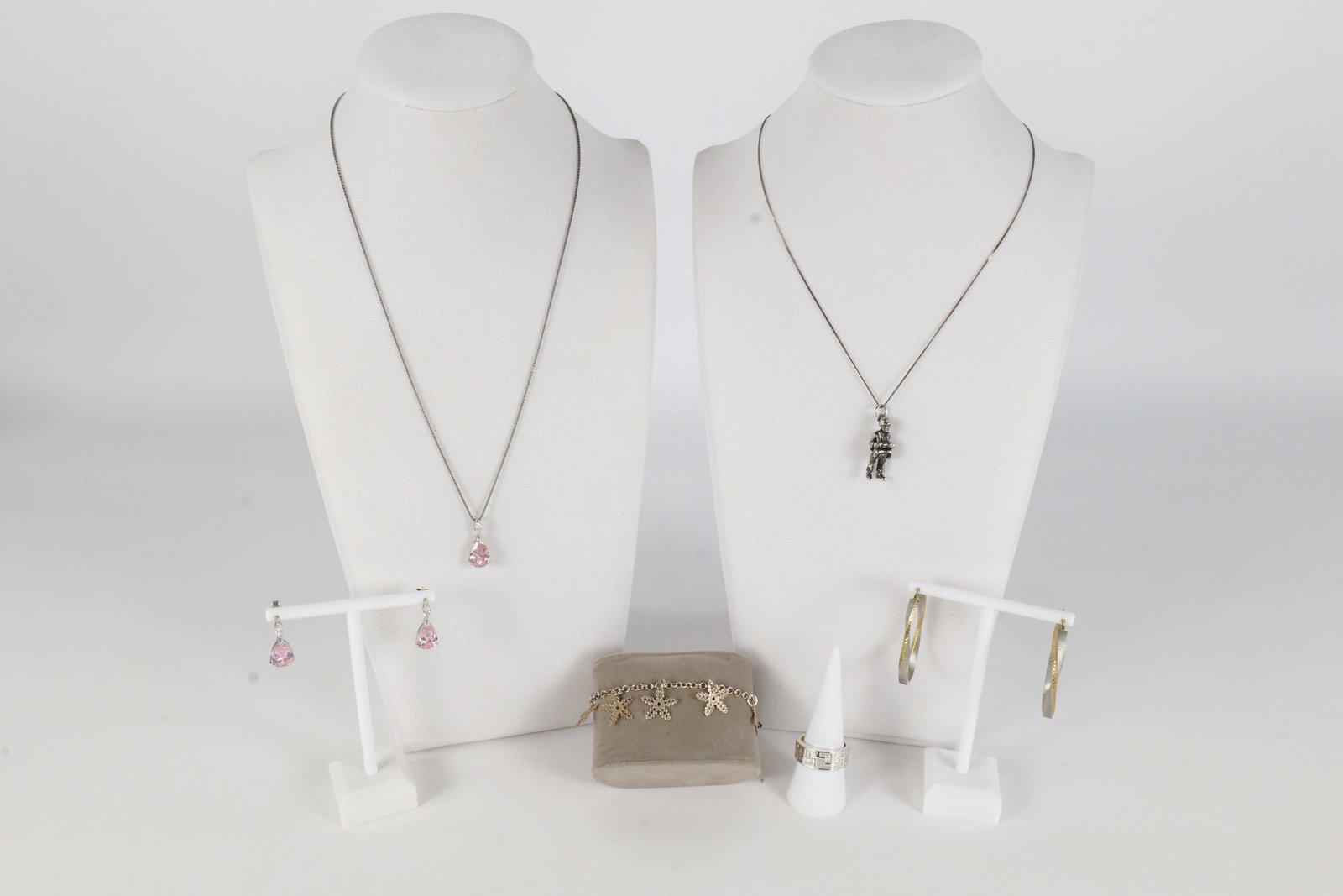 Lot of Sterling Jewelry: Lot of sterling silver jewelry including a pair of silver and gold tone sterling oval hoops, a sterling and simulated stone pendant and earring set, a sterling silver ring with a Greek style etching o