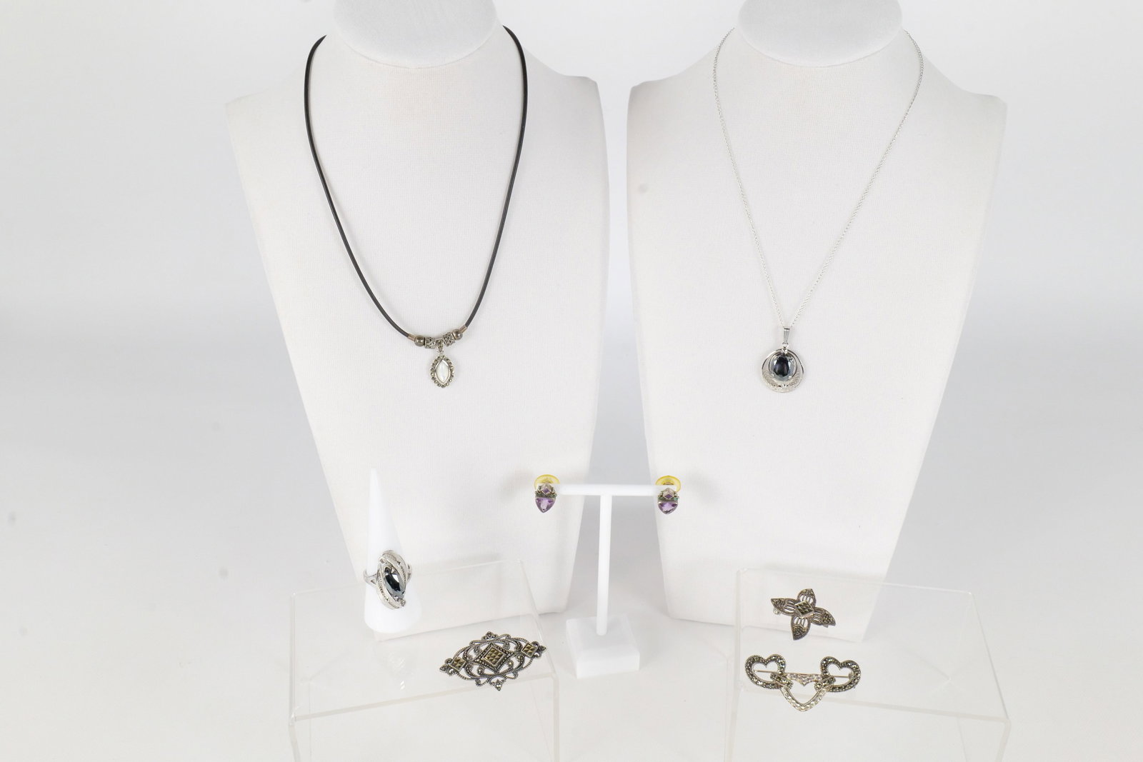 Lot of Sterling Jewelry: Lot of sterling silver jewelry including a sterling silver necklace with a hematite filigree pendant, a marcasite pin, a marcasite heart pin, a marcasite floral pin, a filigree ring, a leather and ste