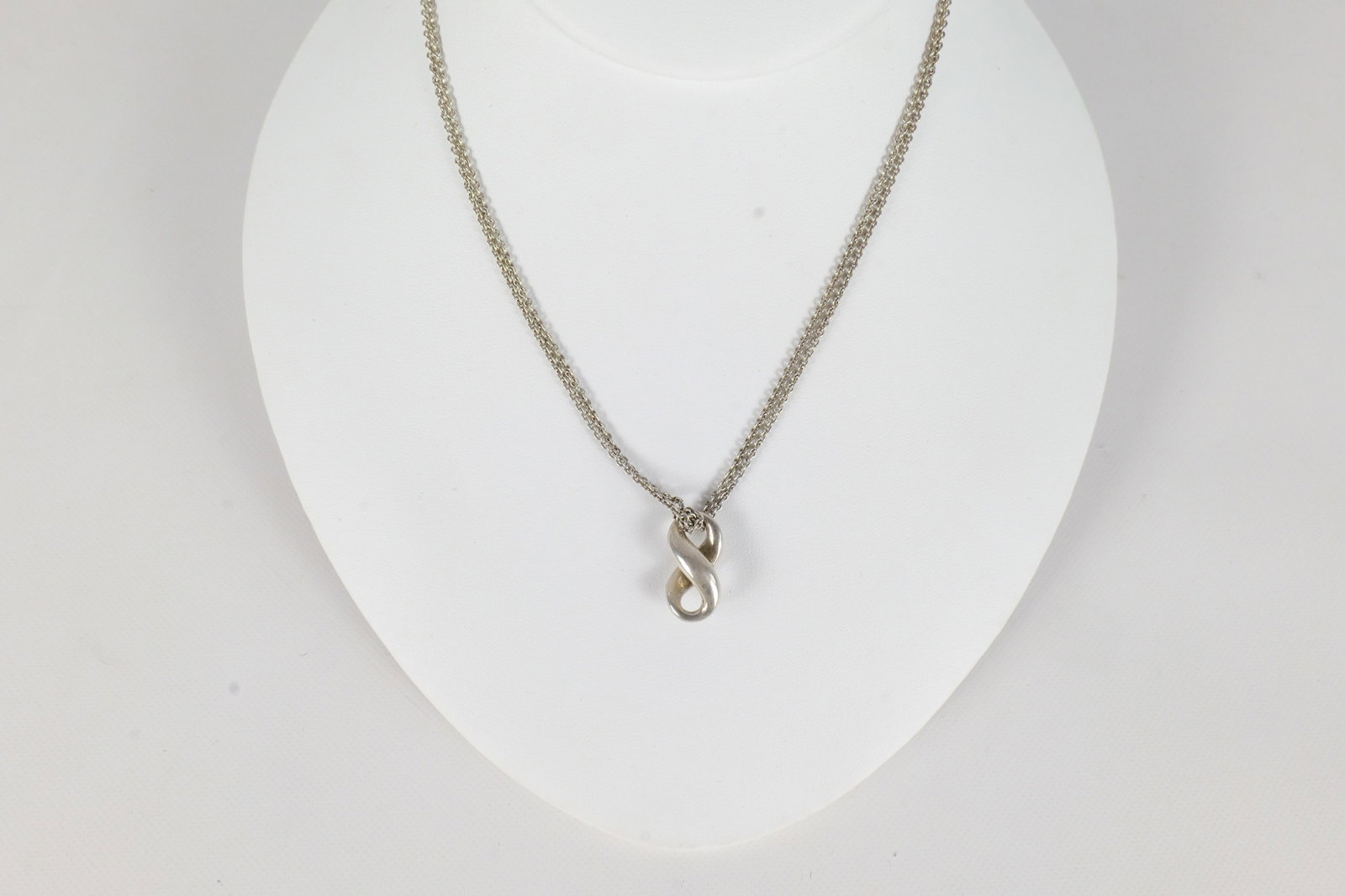 Tiffany & Co Necklace: A Tiffany and Company double Strand necklace with an Infinity Pendant. The necklace measures approximately 15". All invoices must be paid within 24 hours of the sale. We offer multiple shipping option