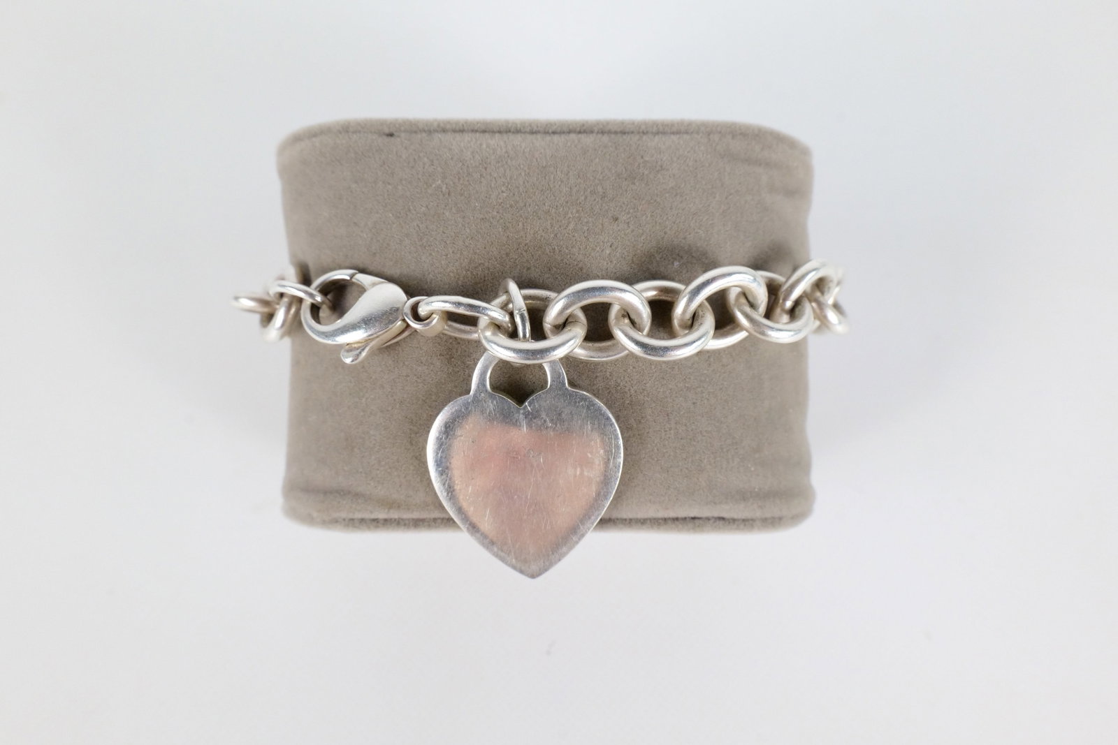Vintage Tiffany & Co Bracelet: Vintage Tiffany and Company Sterling Silver property of Bracelet. Has the typical Tiffany and company heart charm at the end. Is heavily scratched with some dings. The bracelet measures approximately 