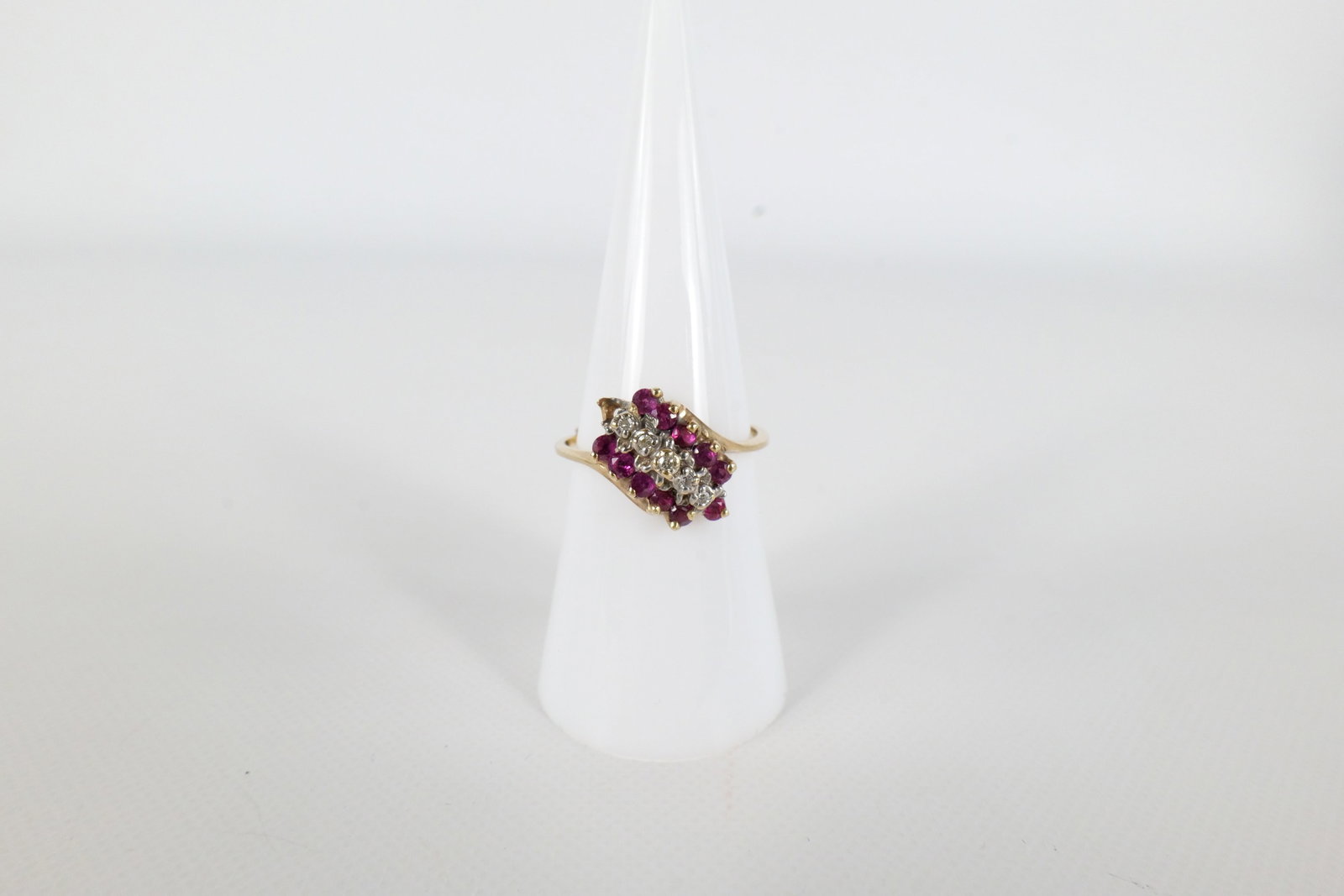 10K Diamond and Ruby Ring: A 10 K yellow gold ladies ring. Has two rows of rubies and one row of small diamond chips on the front. Is missing one Ruby at the end. Is marked tru glo on the inside of the band. Is Mark 10 K. Size 