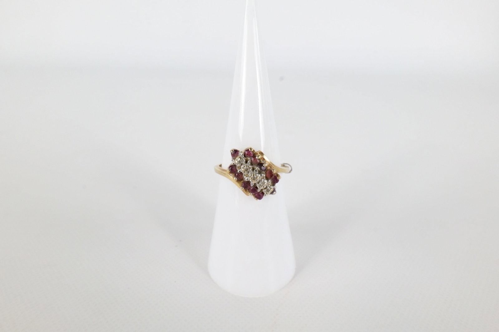 10K Diamond and Ruby Ring: A 10 K yellow gold ladies ring. Has two rows of rubies and one row of small diamond chips on the front. Is missing one Ruby at the end. Is marked tru glo on the inside of the band. Is Mark 10 K. Size 
