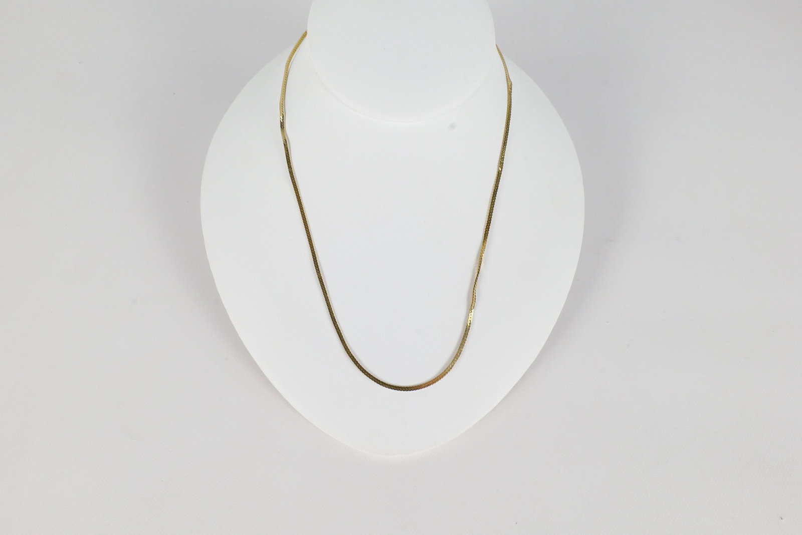 14K Yellow Gold Necklace: A 14 K yellow gold herring bone chain. Is marked near the clasp. Has kinks throughout. The necklace measures approximately 17" and weighs approx. 3.9 g. All invoices must be paid within 24 hours of th