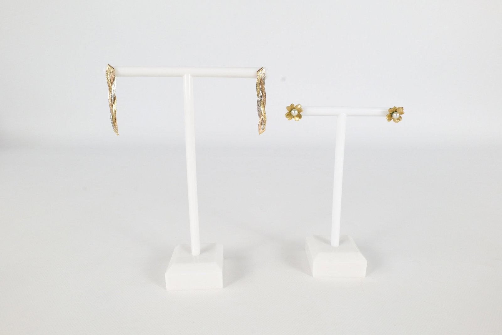 2 Pairs 14K Earrings: Two pairs of 14K earrings. The first is a tri colored gold braided rope style drop earring. The second pair is a small pair of pearl studs and a floral style. They are both tested and not marked. The
