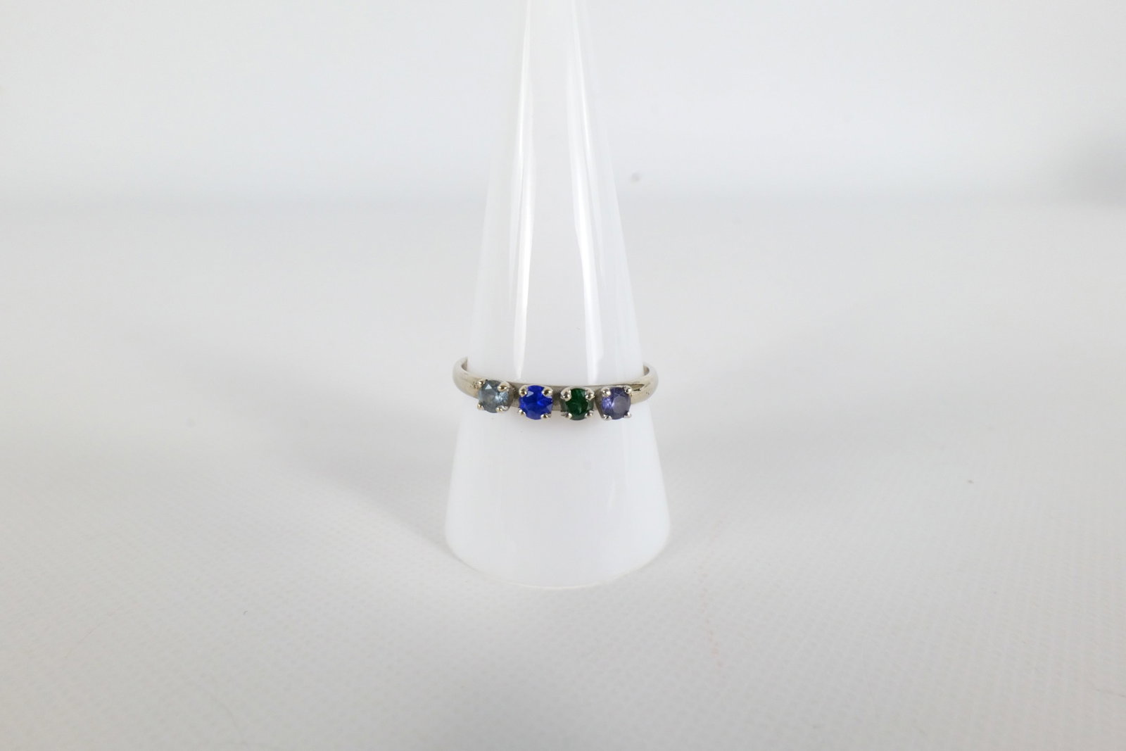 14K Gemstone Ring: A 14K white gold ring with four round cut gemstones in the front. Is inscribed inside the band 5-14-72. Size 9 3/4. Weighs approx. 2.2g with the stones. All invoices must be paid within 24 hours of