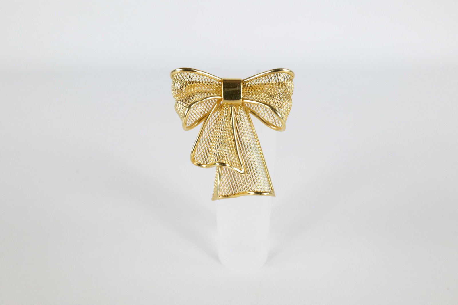 18 K Ribbon Pin: An 18K yellow gold mesh bow pin. Has a solid 18 K border around the bow with a mesh interior. Is marked on the back 18K Italy. Measures approximately 1 1/4" long. Weighs approx. 5.3g. All invoices